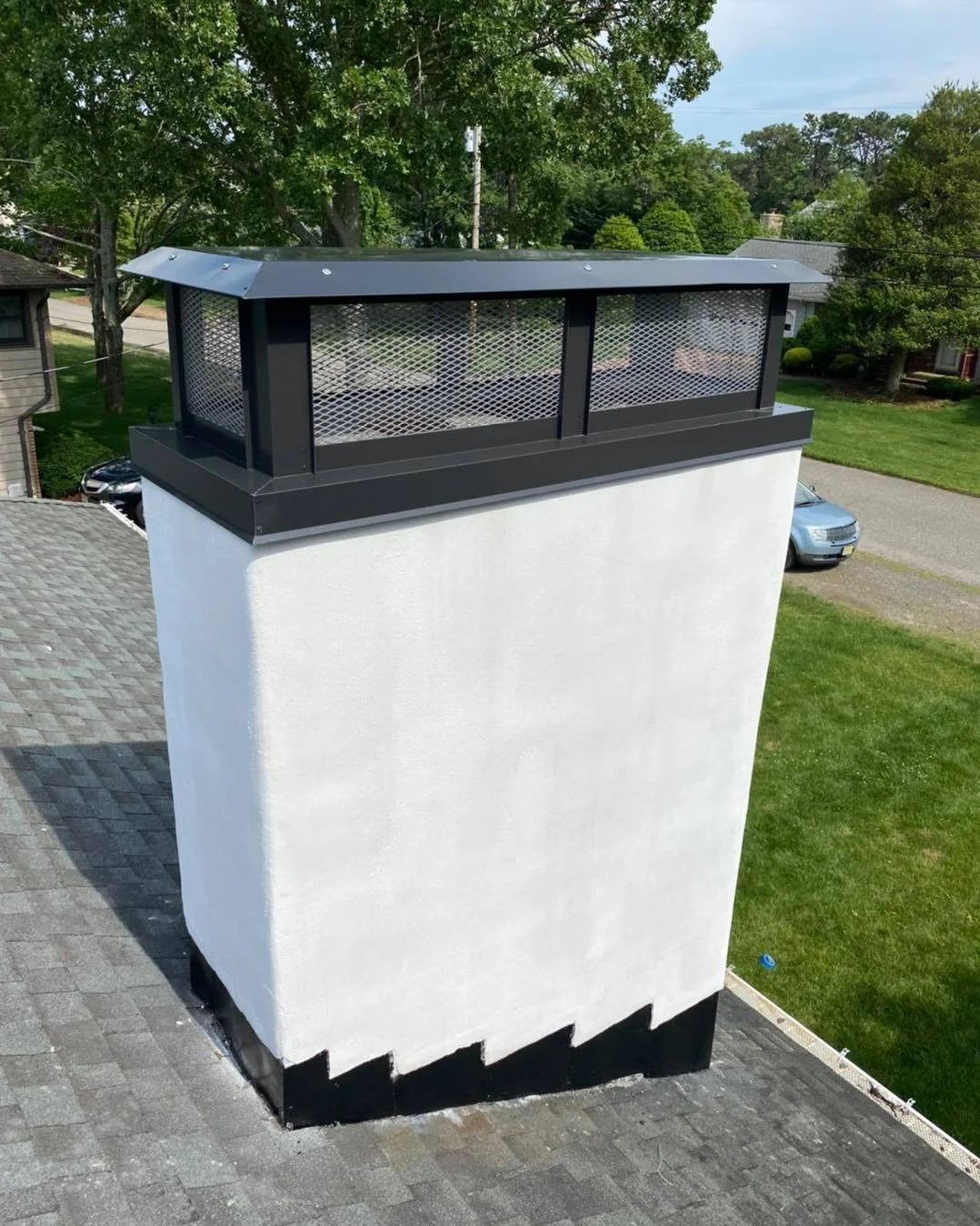 Chimney repaired with stucco and a custom black chimney cap. 