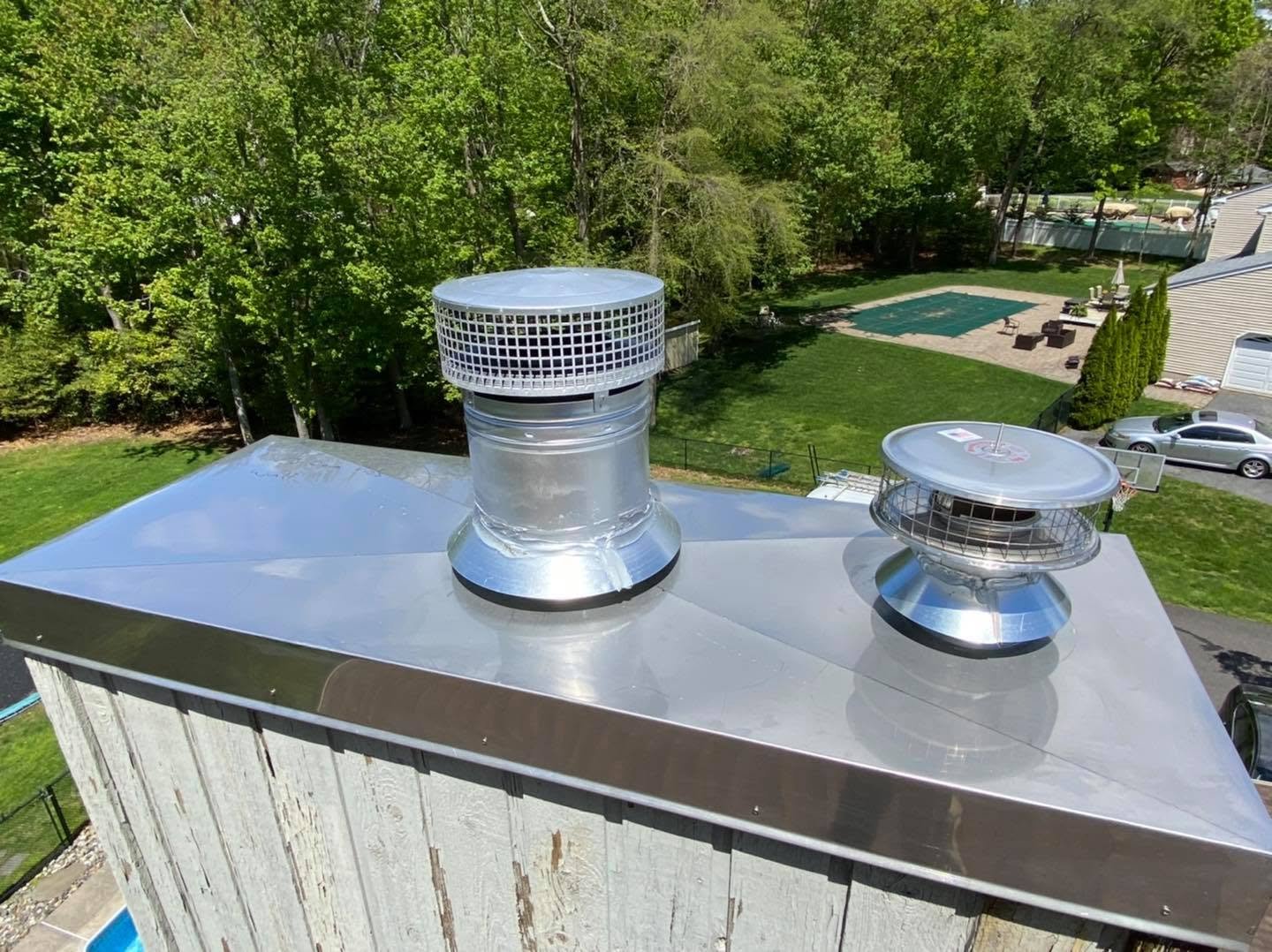New custom stainless steel chase cover installed. Also new chimney cap on the right installed as well as the old one failed. 