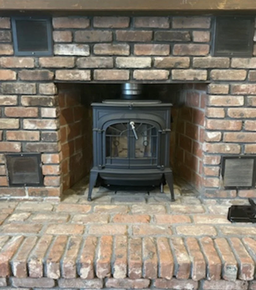 Free standing wood stove with new liner installed into a fireplace for efficiency 