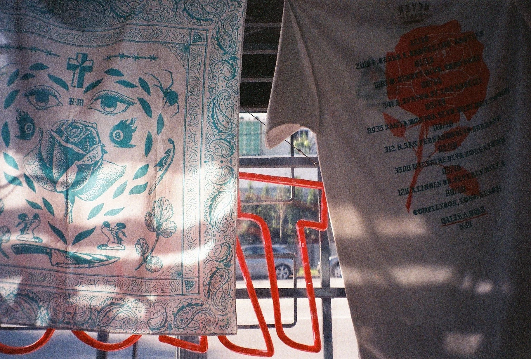 light flickering off of a scarf and shirt hanging in the glowing light of the window