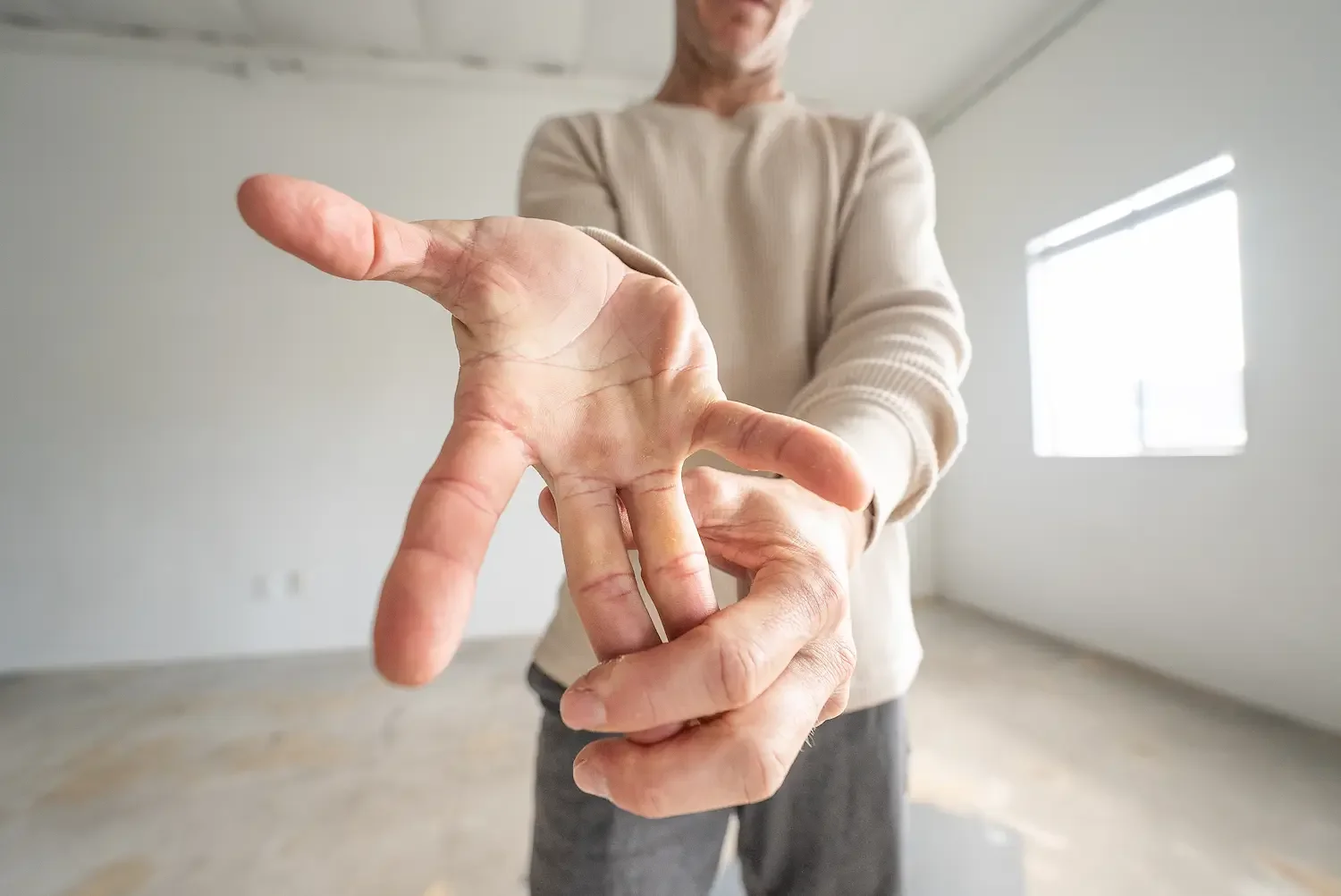 Close-up of a man's hand forming a mudra gesture in a bright studio