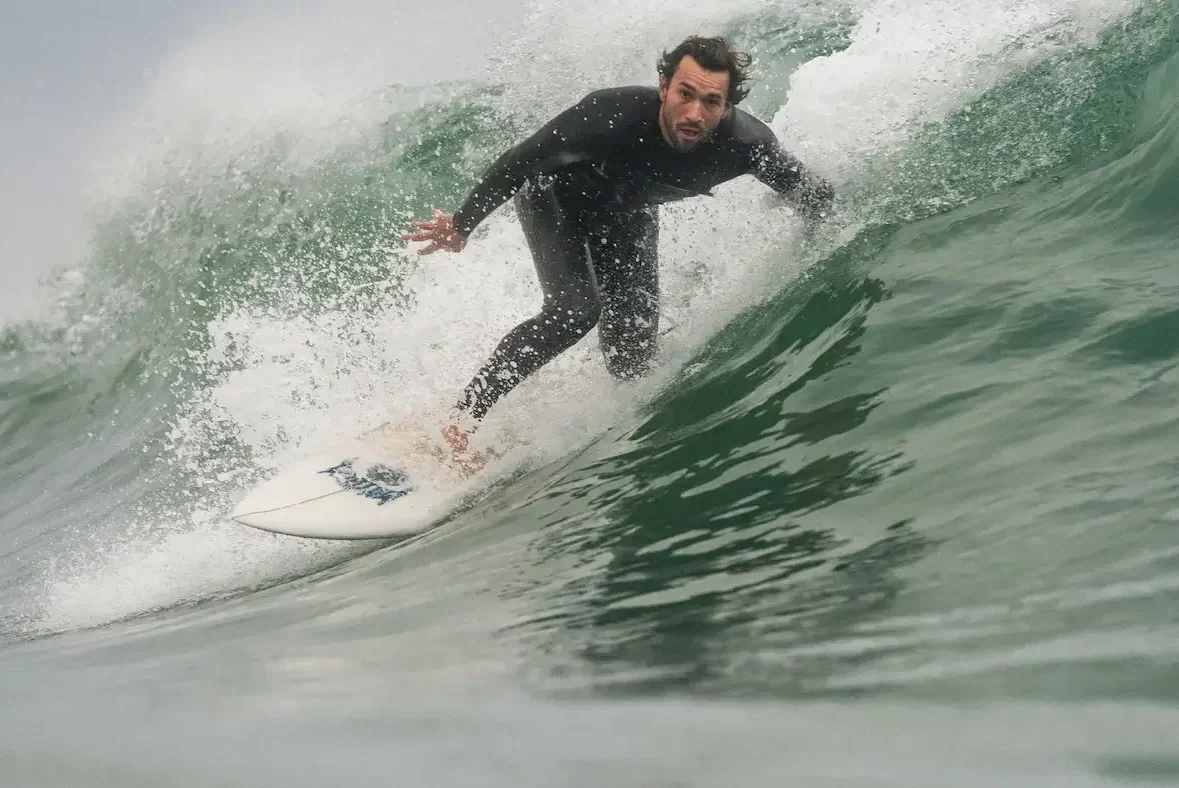 A man surfing on a wave in the ocean.