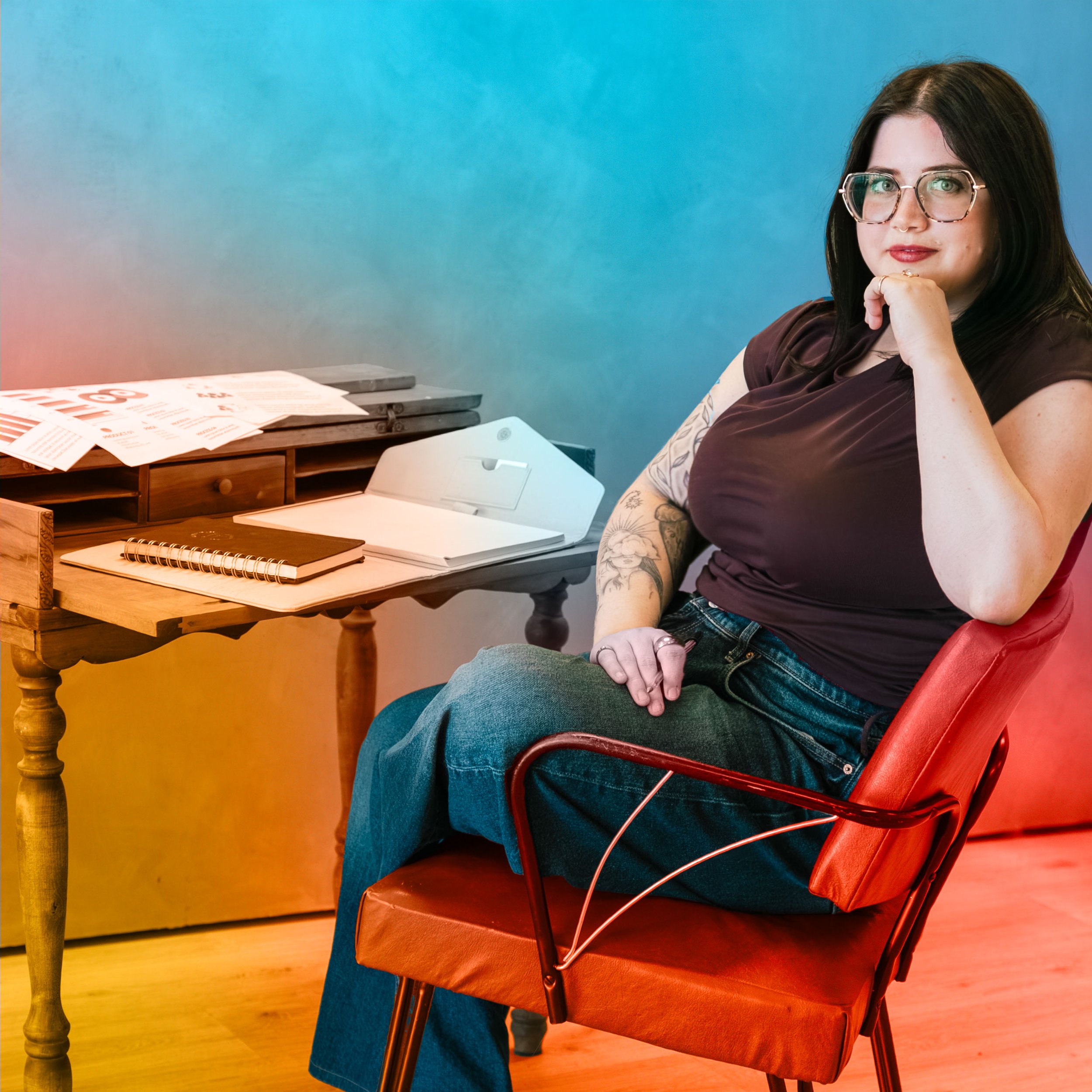 An image of Lily sitting at a wooden desk with notebooks and reports on it