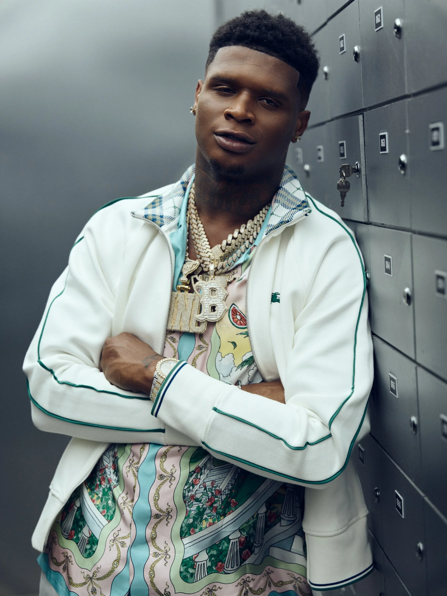 Vertical portrait of HoodTrophy Bino beside a wall of numbered metal lockers