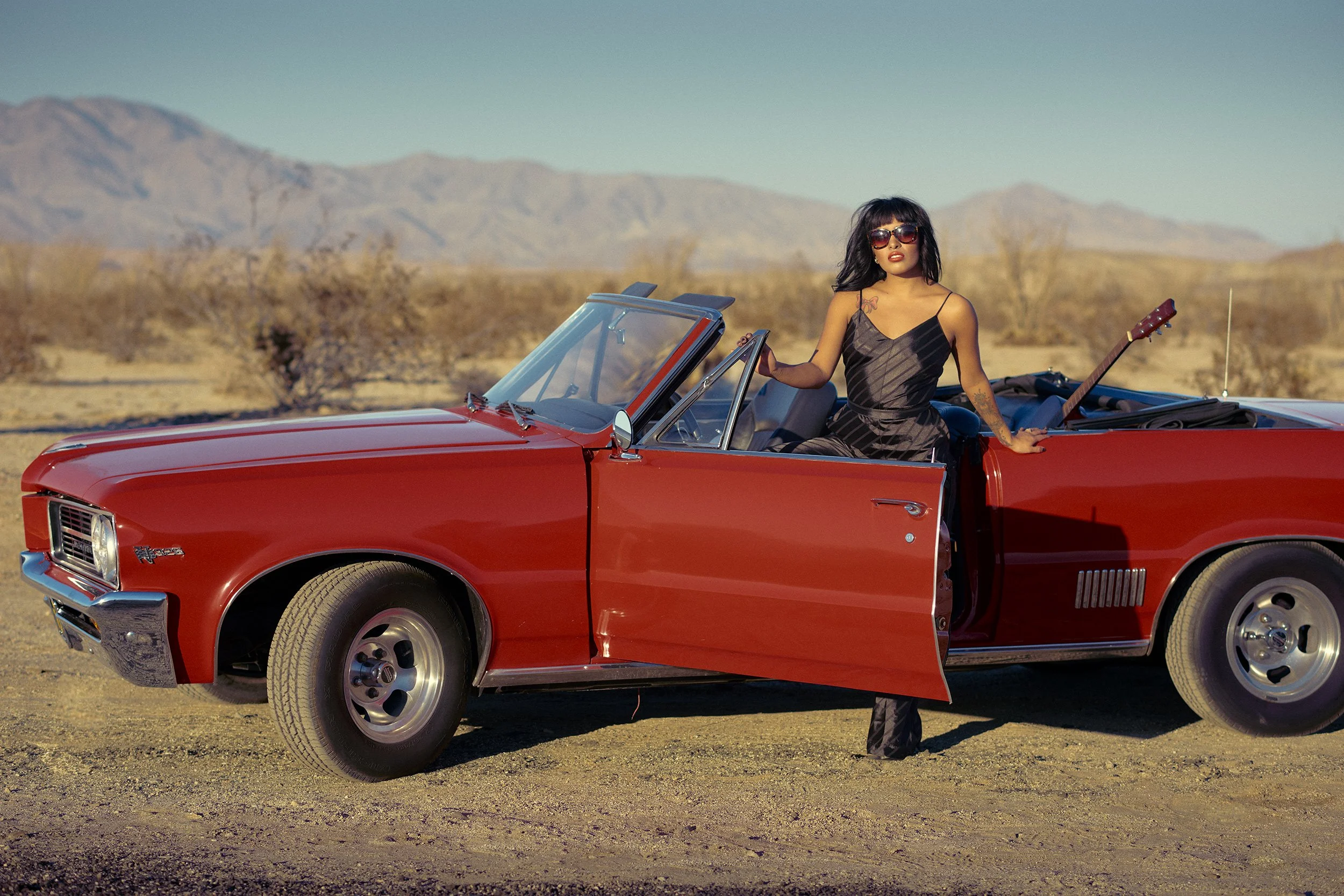 Lisa Jennigs beside a vintage red convertible during the WESTBOUND fashion editorial in Anza-Borrego.