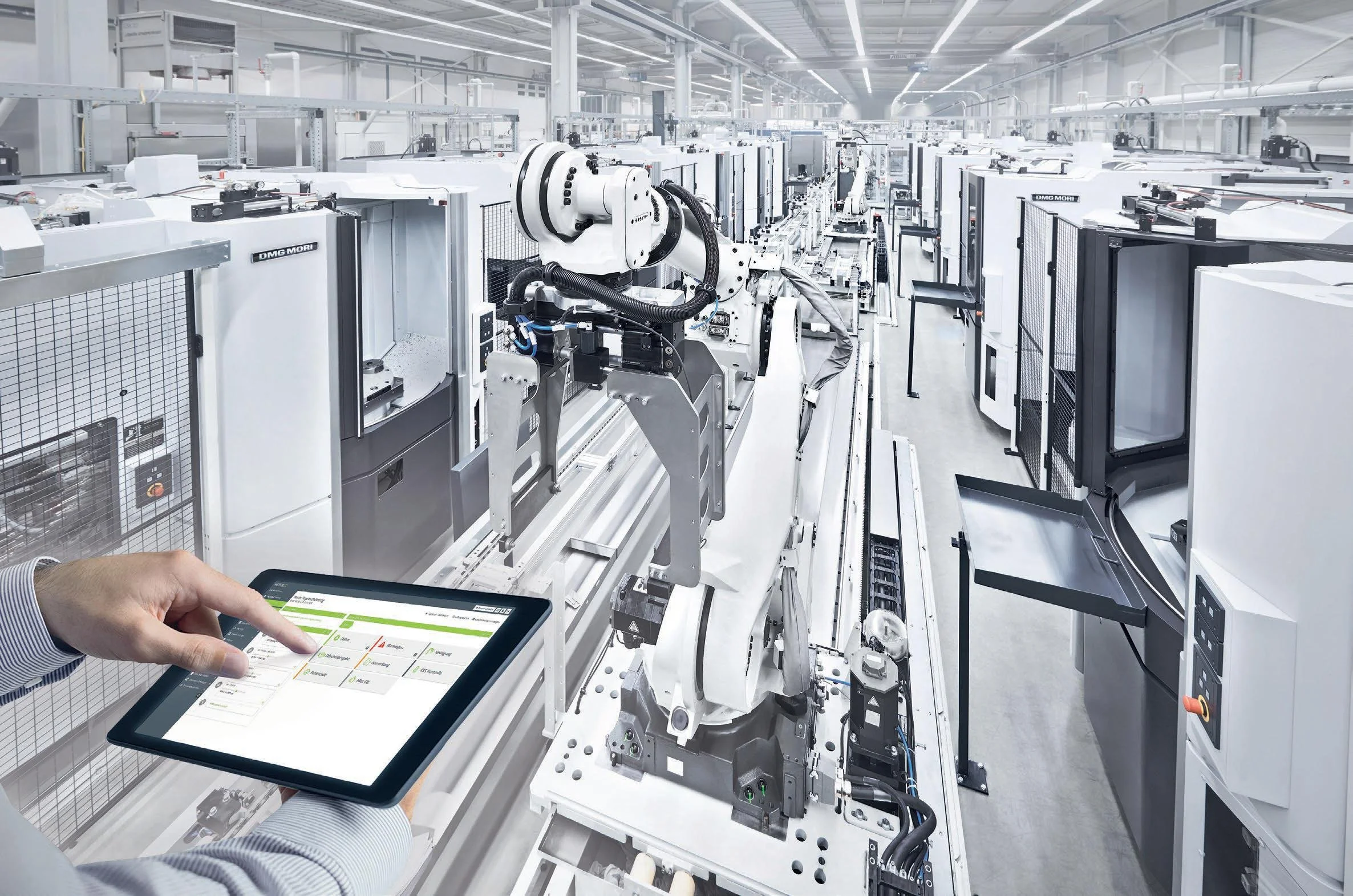 A person holding a tablet in front of industrial machinery in a manufacturing plant.
