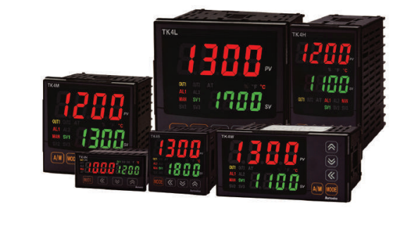 A collection of digital industrial temperature controllers with black casings, red and green LED displays showing temperature readings, and various control buttons.