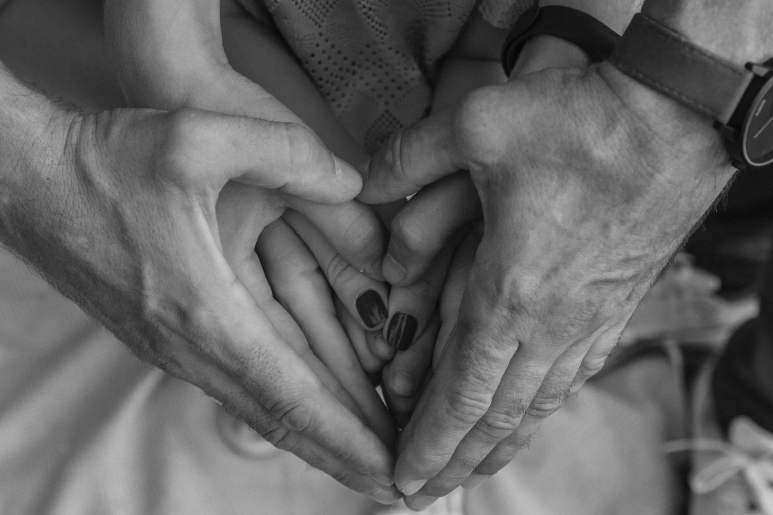 Multiple hands forming a heart