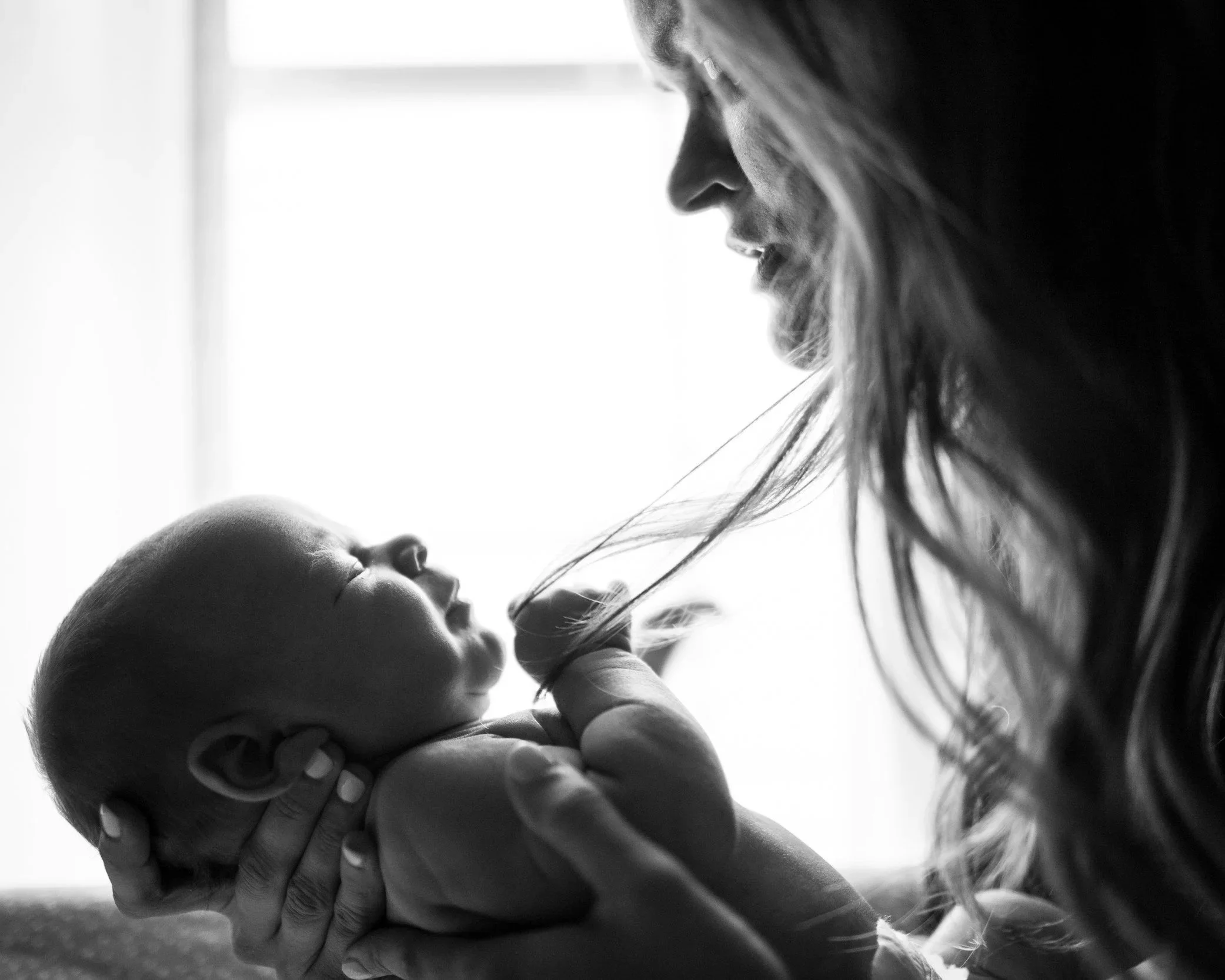 a mother holding and looking at her newborn baby