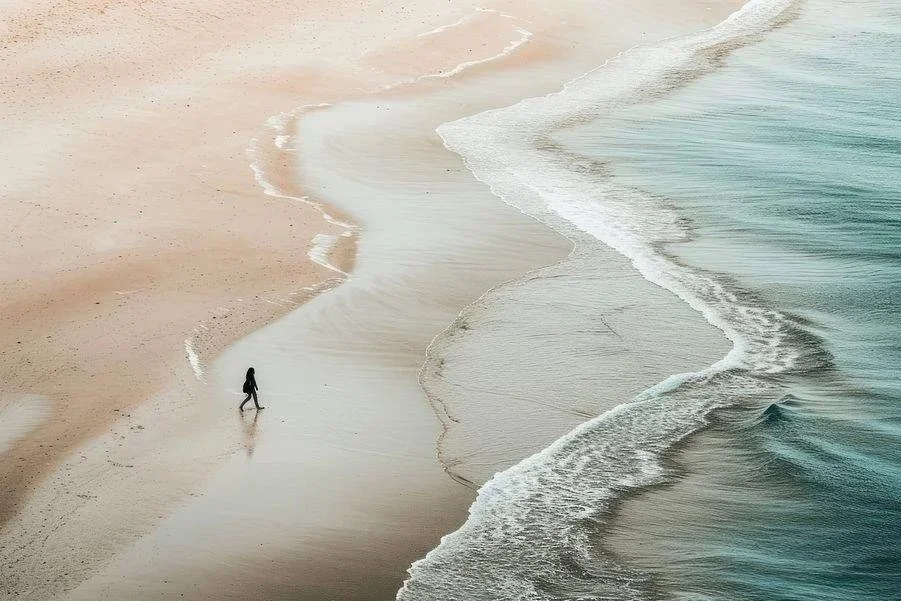 A person walking along a peaceful beach, representing healthy boundaries and emotional well-being.