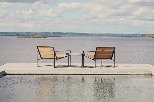 Two chairs overlooking a peaceful lake, representing healthy communication and relationship connection.