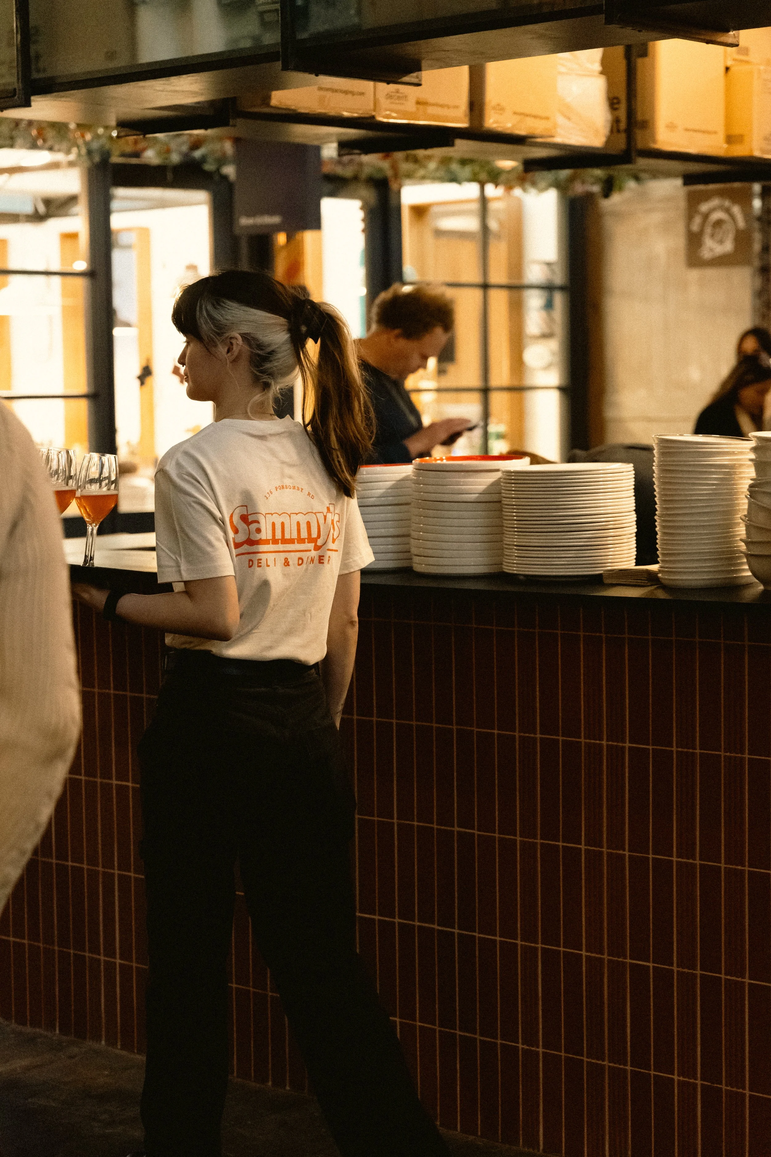 Restaurant branding for Sammy's Deli & Diner featuring a branded staff uniform showcasing the custom logo and visual identity created by Aura Studio.