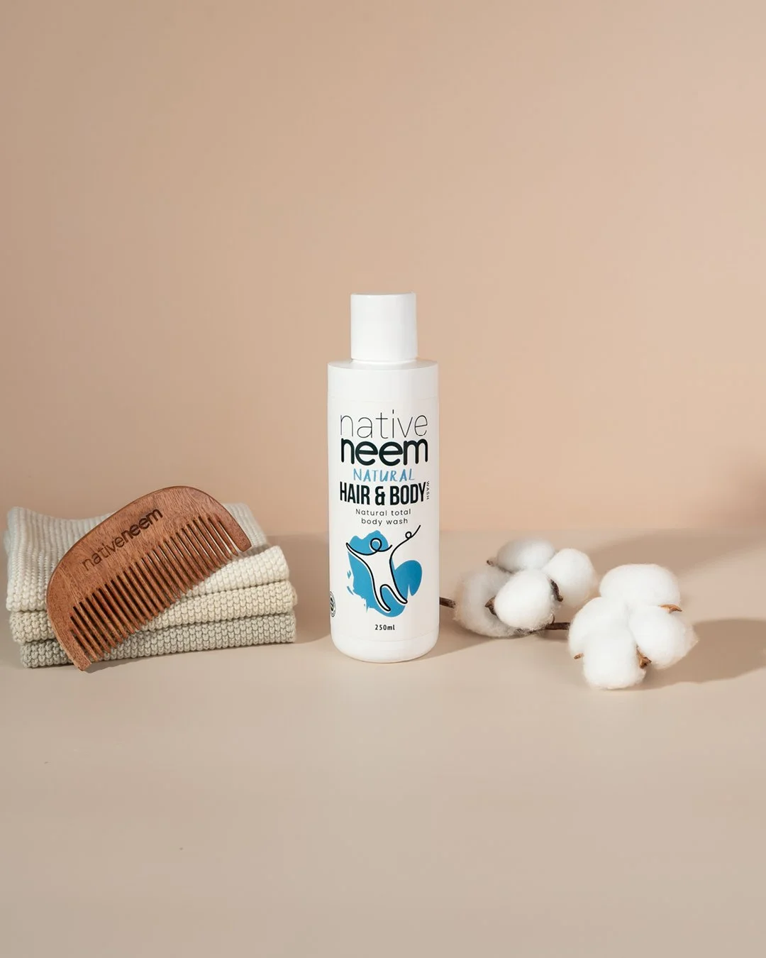 Native Neem Natural Hair & Body Oil styled with a wooden comb and cotton on a warm neutral background.