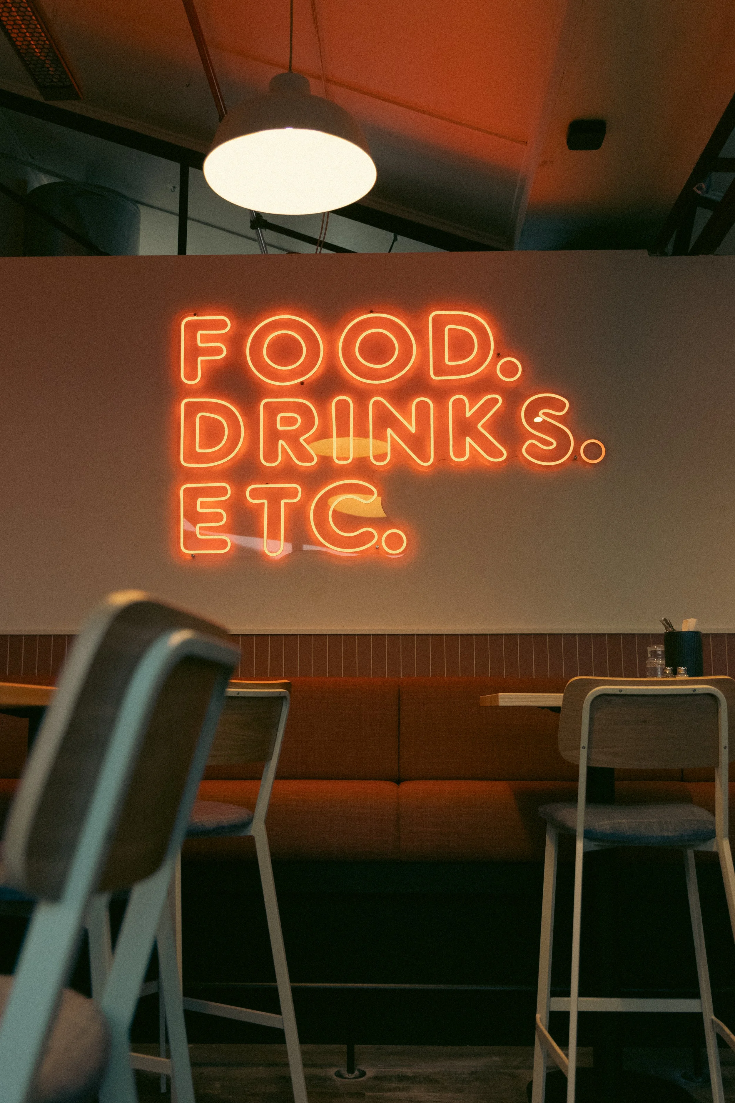 Sammy's interior with orange neon Food Drinks Etc sign photographed by Aura Studio in Auckland.