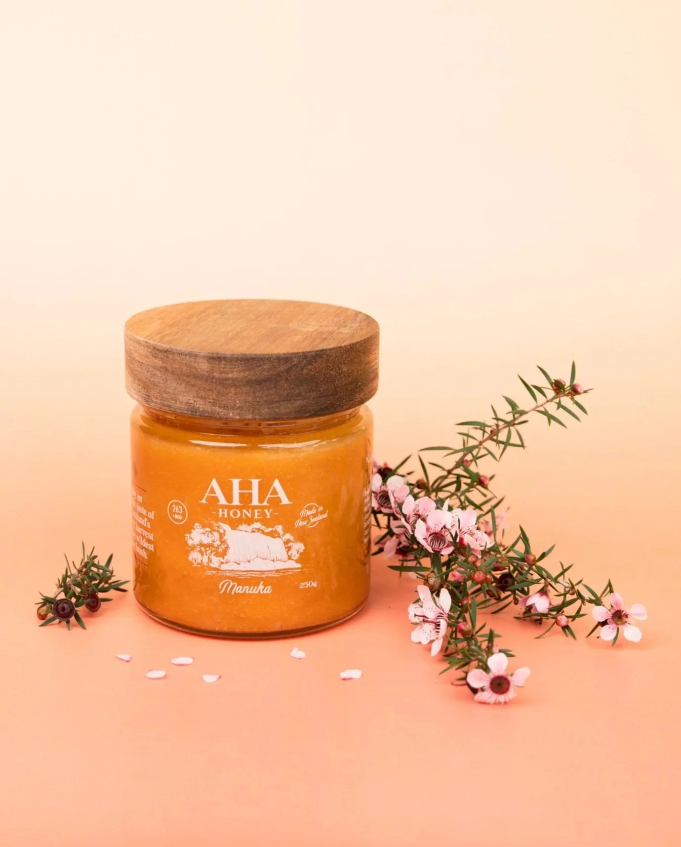 AHA Honey Manuka honey jar styled with Manuka flowers, product photography by Aura Studio in Auckland.