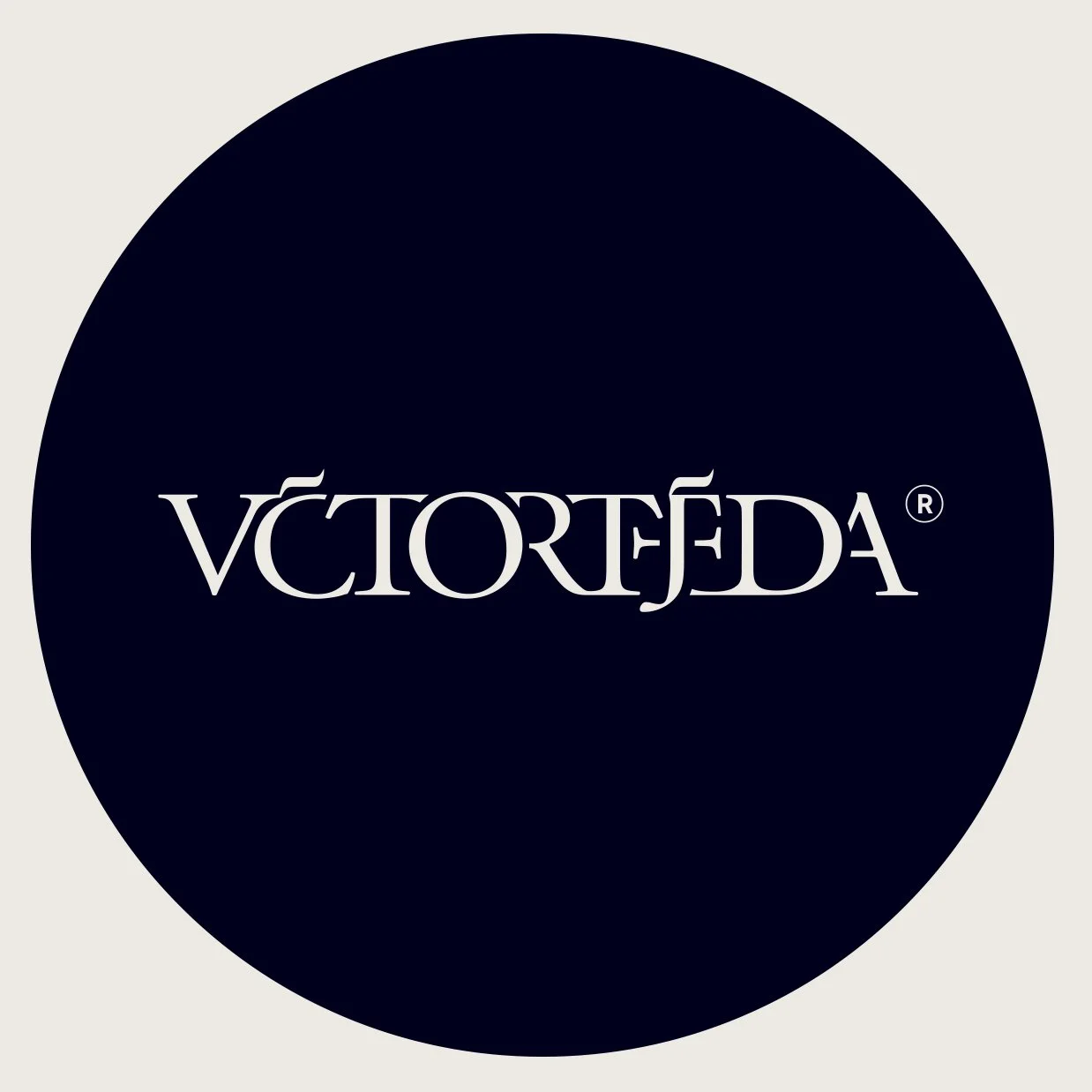 Black circular logo with white stylized wordmark reading "VICTORTEJEDA."