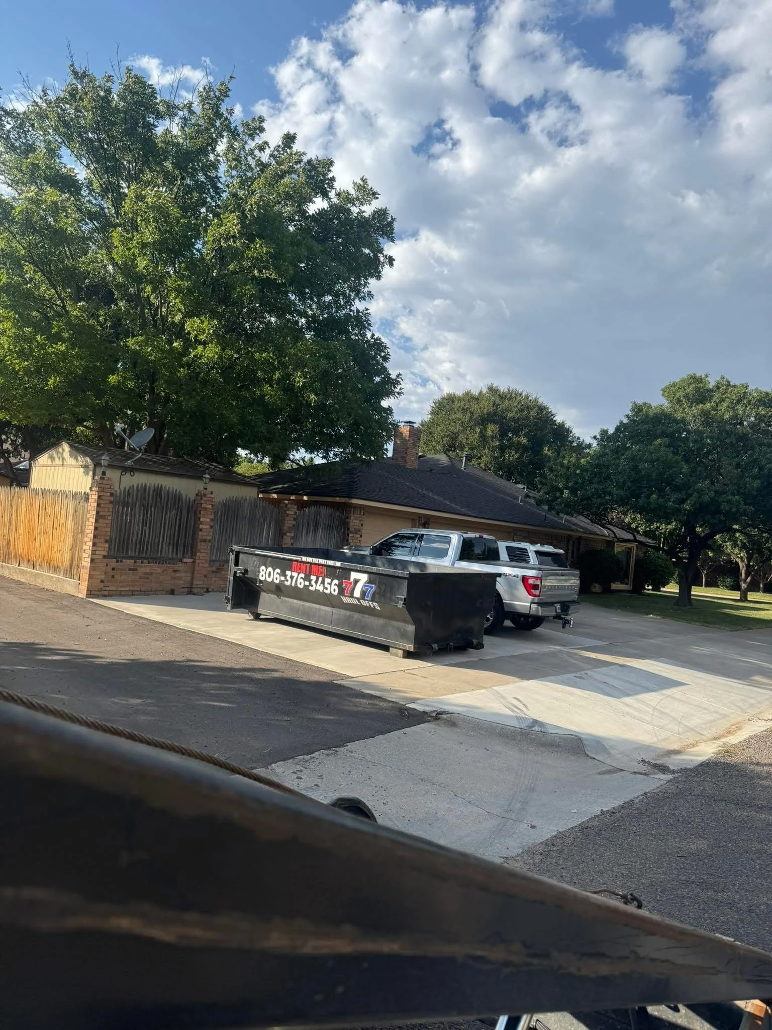 Black 777 roll-off dumpster delivered to a home driveway in the Amarillo area