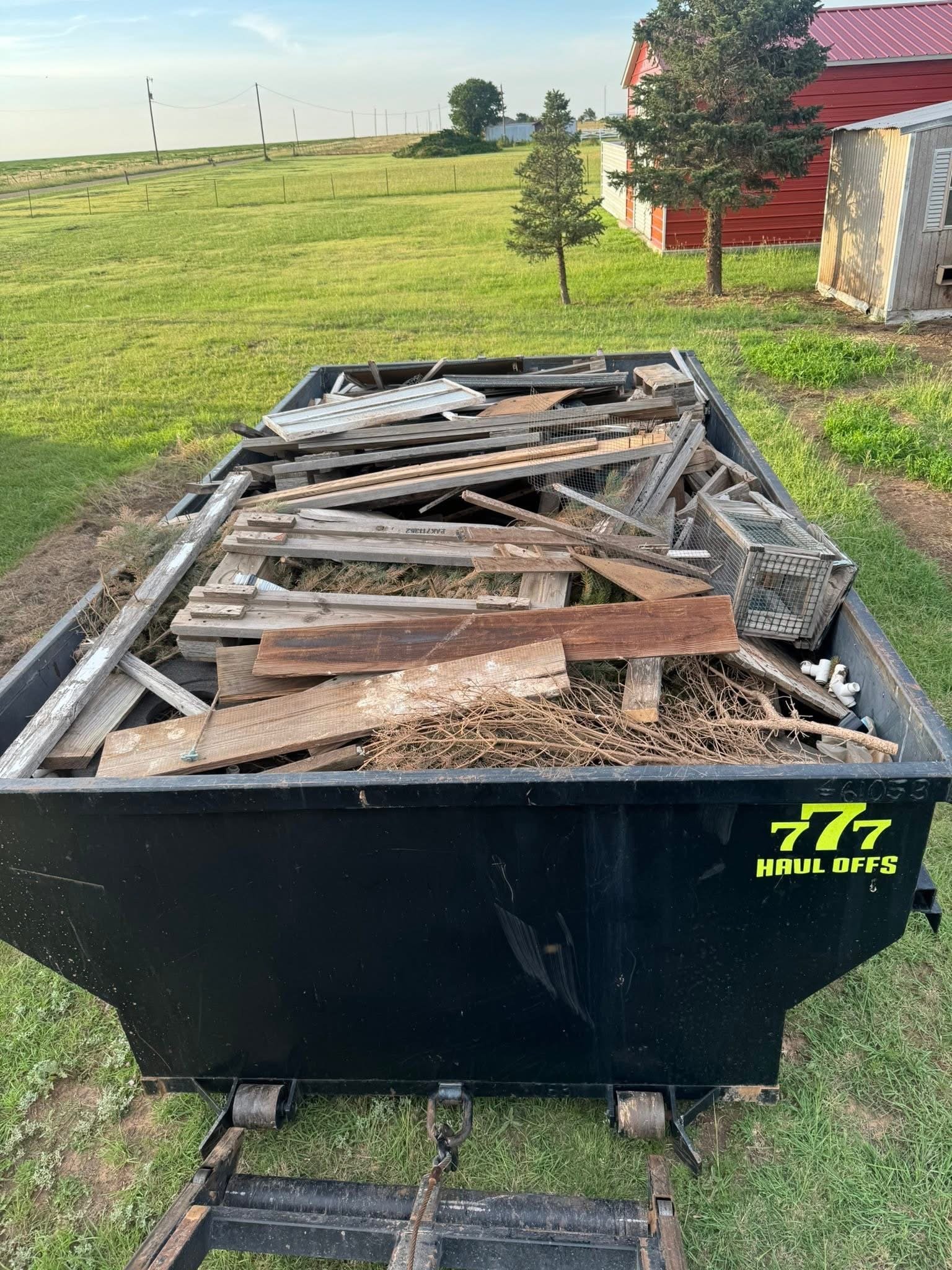 Dumpster filled with old fence boards and scrap lumber from a Panhandle property cleanup