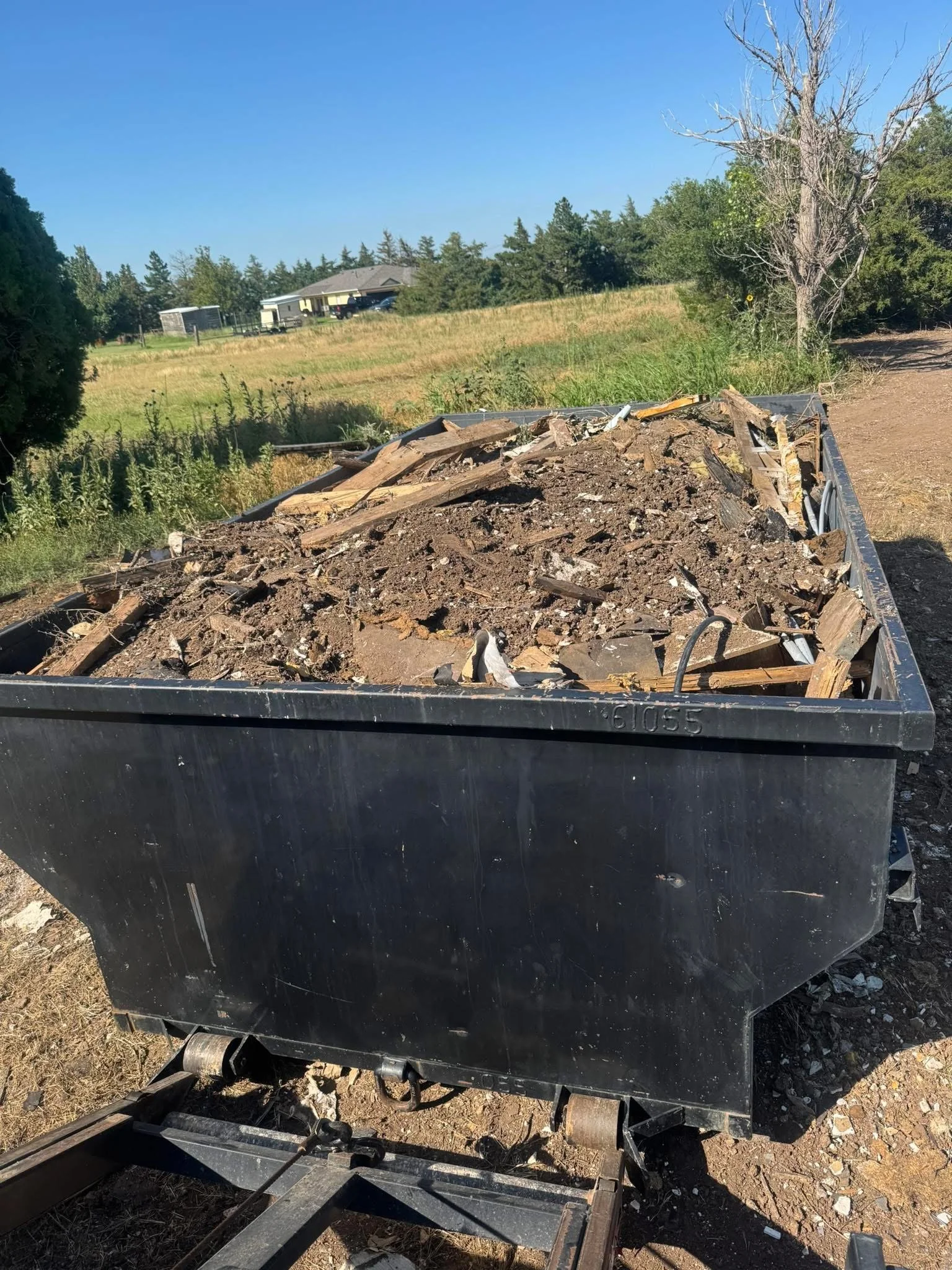 Roll-off dumpster loaded with debris on a rural Texas Panhandle property