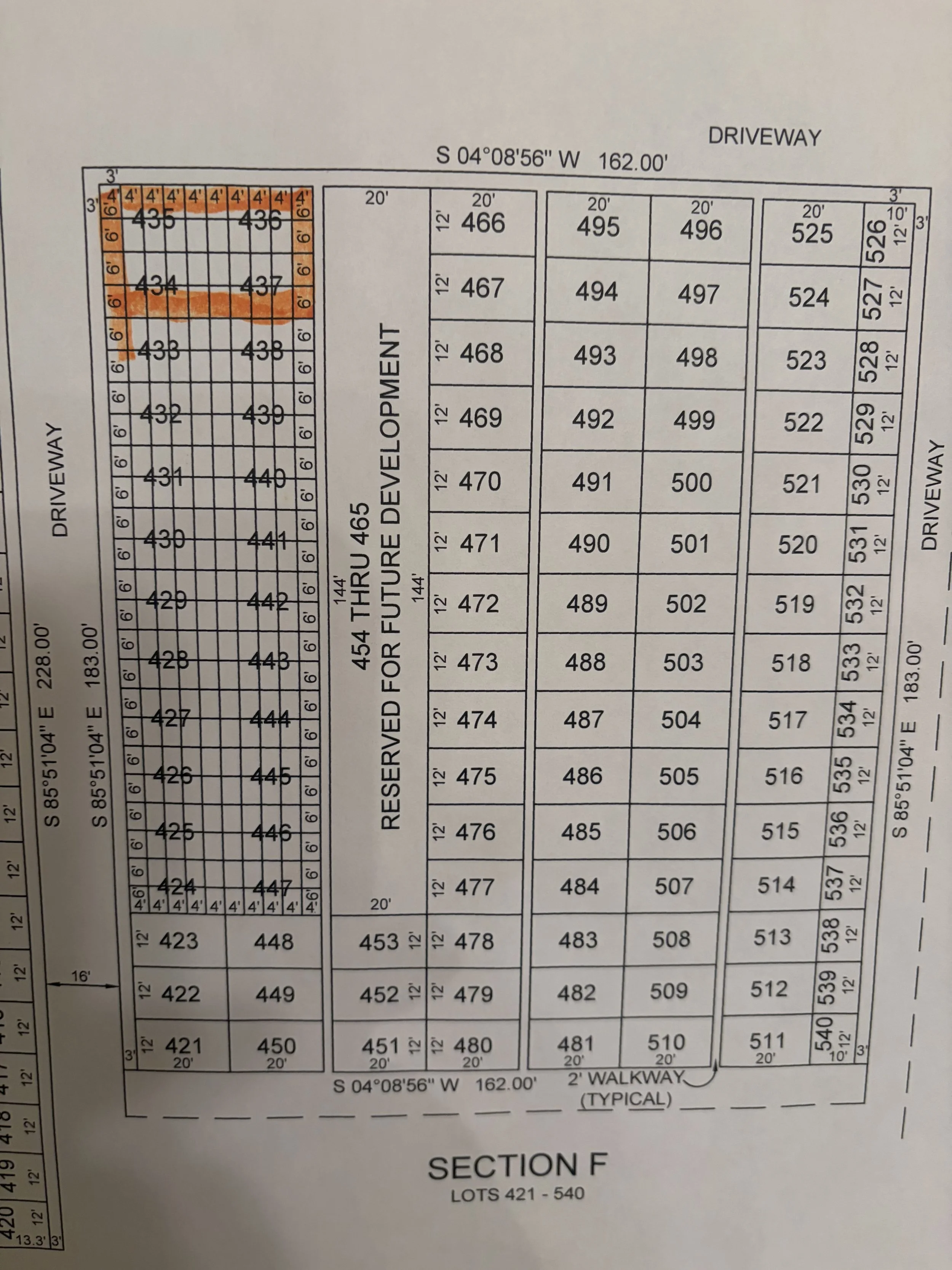A detailed layout plan for a residential development showing numbered lots, streets, and sections, with some areas highlighted in orange.
