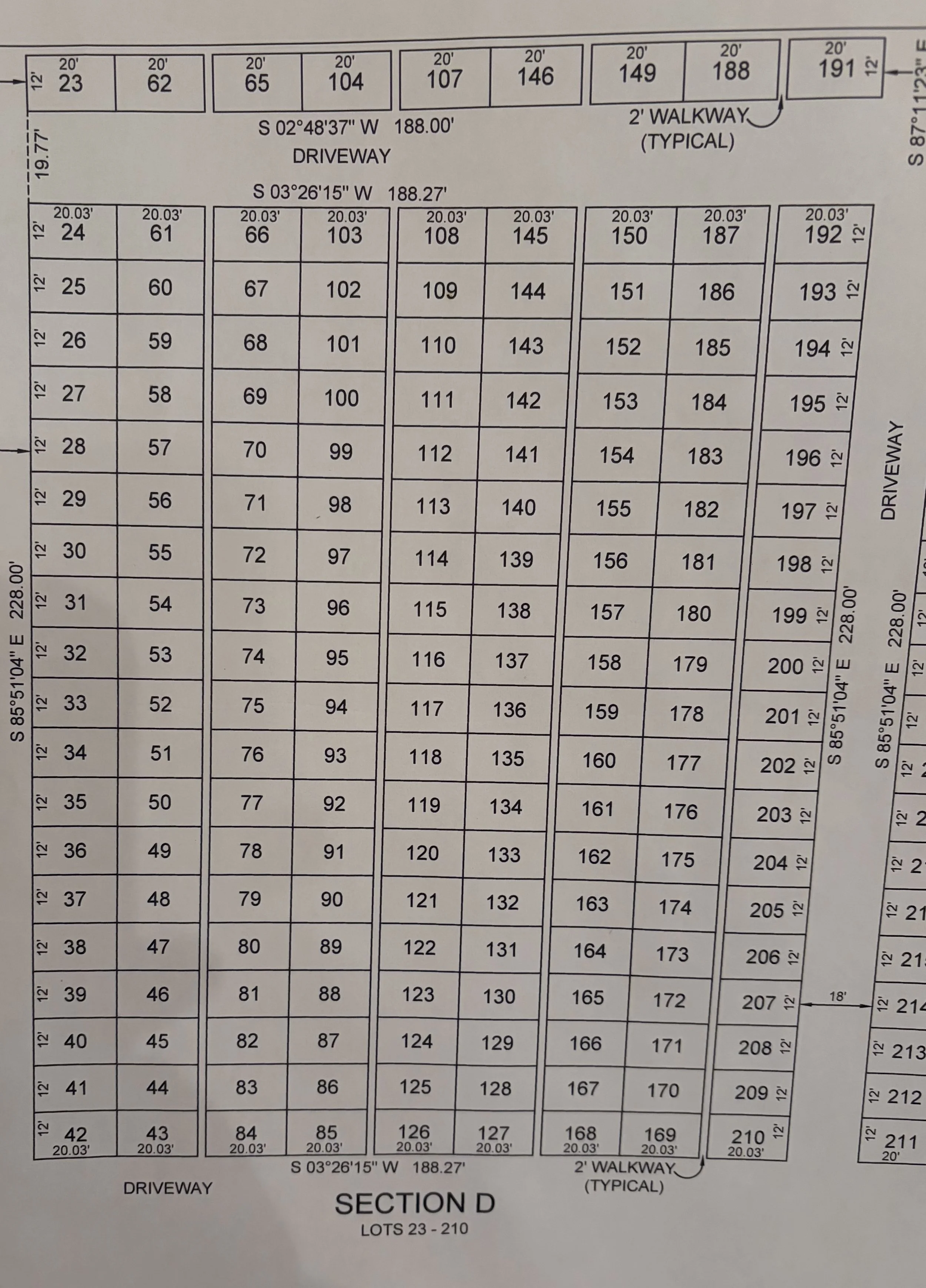 A detailed lot and section map showing numbered parcels, driveways, walkways, and measurements for a subdivided area. The map indicates lots numbered 23 to 210, with section D labeled for lots 23 to 210, and includes street information and dimensions.