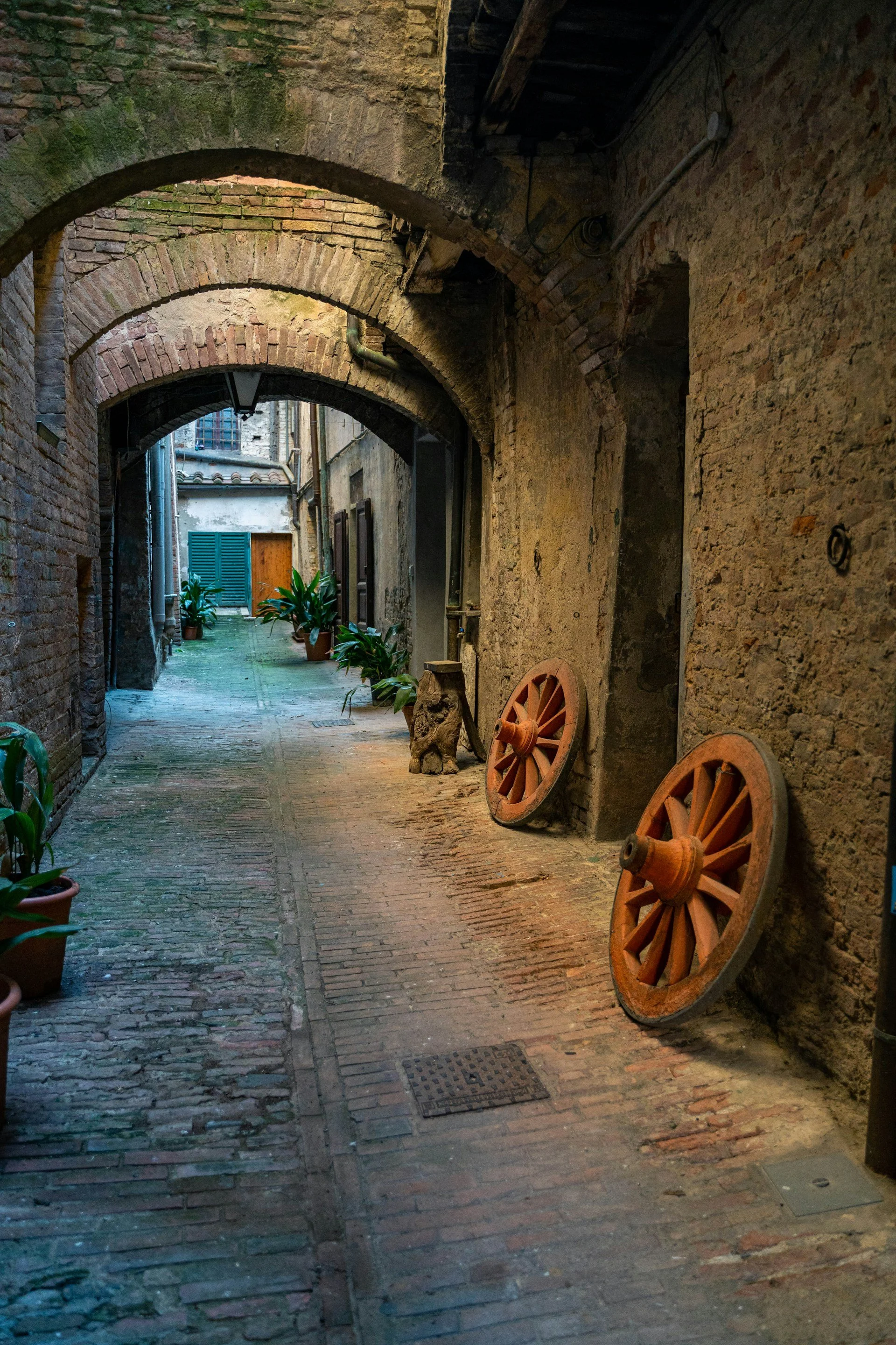 Historic Mediterranean passage with wooden cart wheels, reflecting place, memory, tradition, and everyday cultural life.