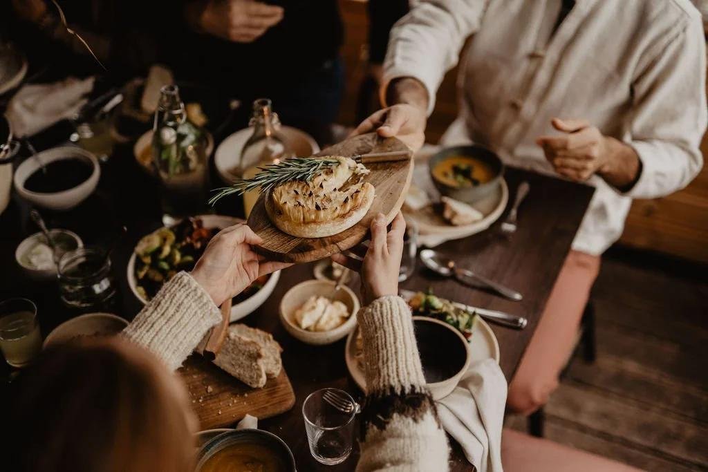 People sharing food around a table, illustrating gastrodiplomacy and cultural exchange.