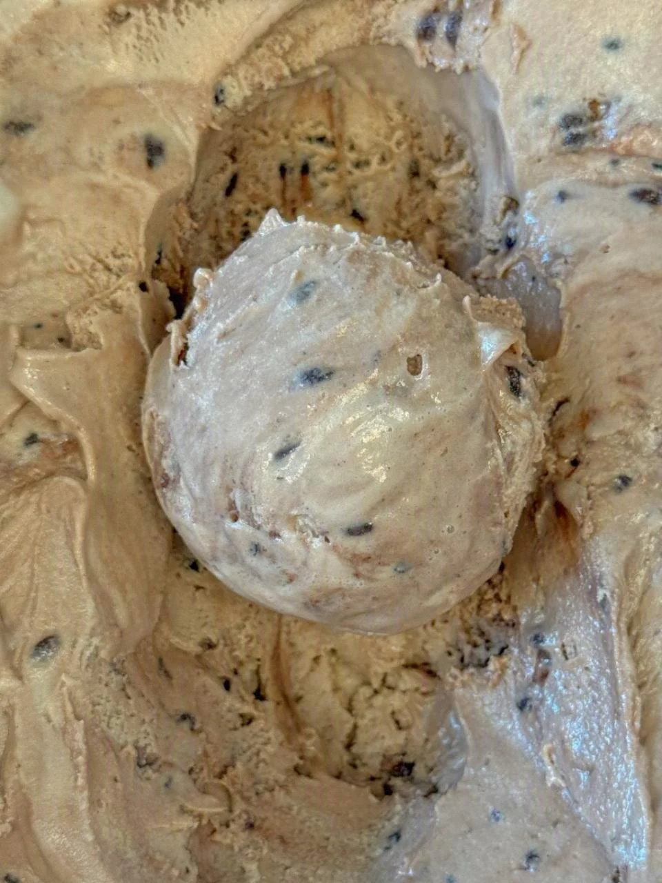 Close up of a light brown scoop of Hazelnut Crunch ice cream