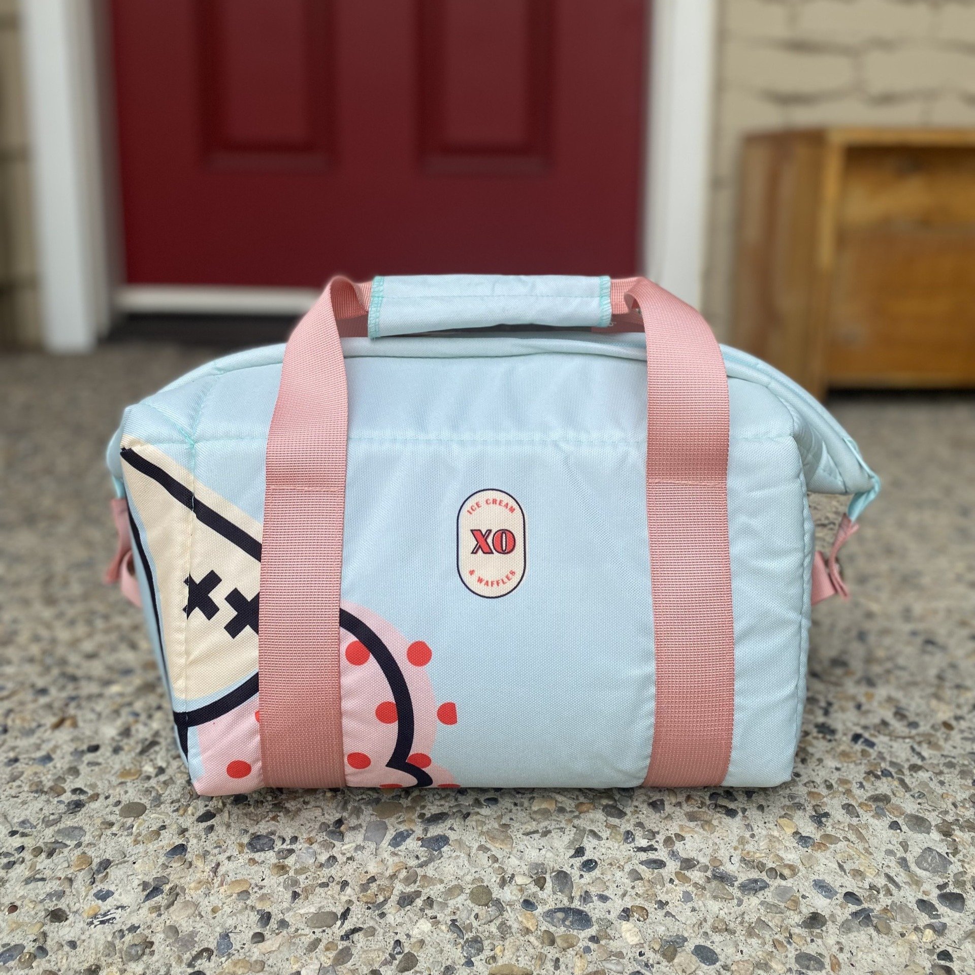 Soft shell cooler with XO colours and logo, on a front porch