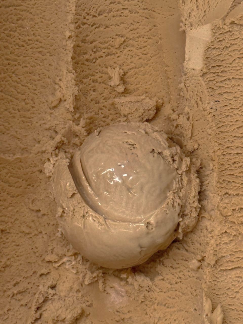 Close up of a brown scoop of Salted Caramel ice cream.