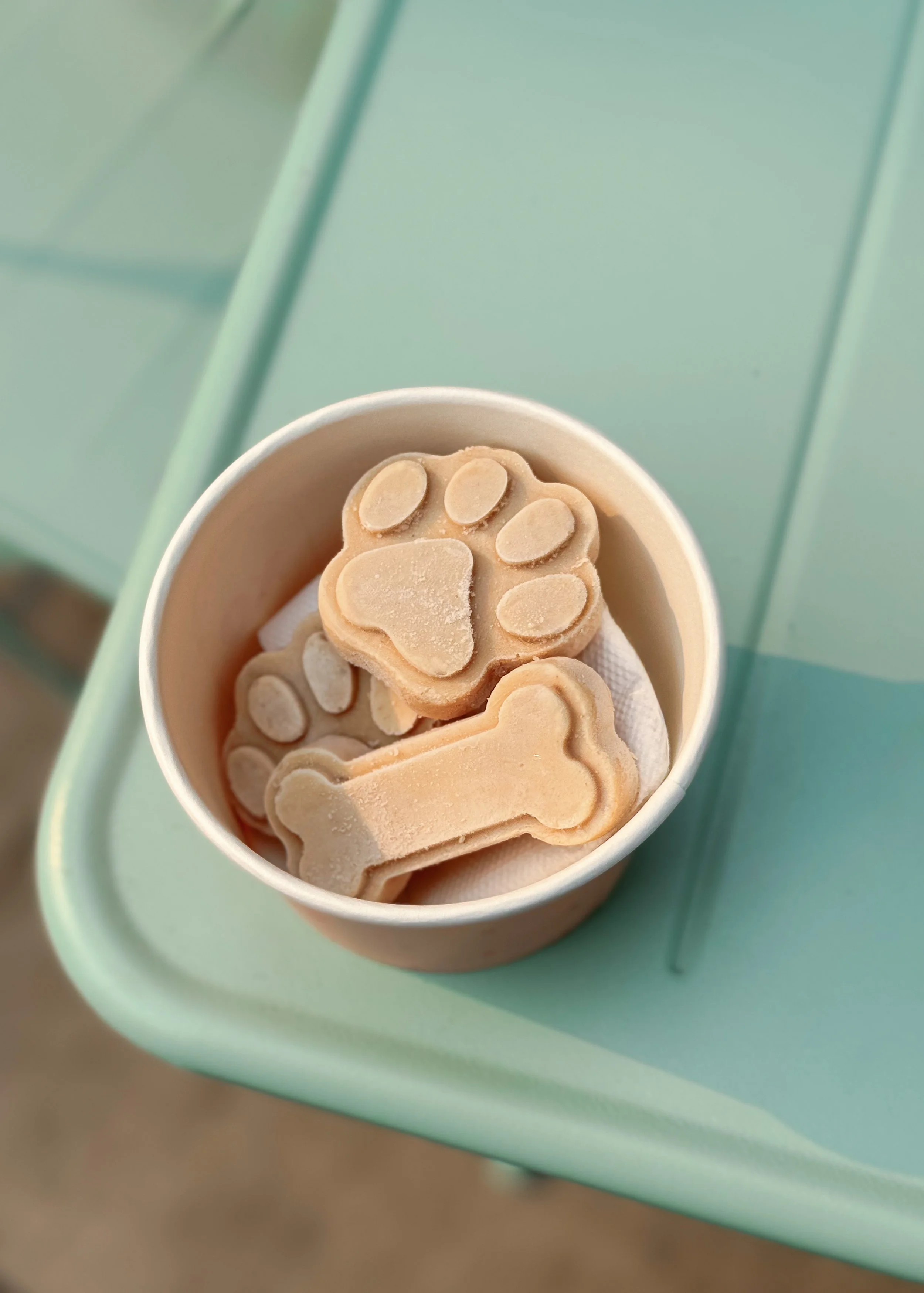 Frozen treats in the shape of paws and bones made with peanut butter and banana for dogs