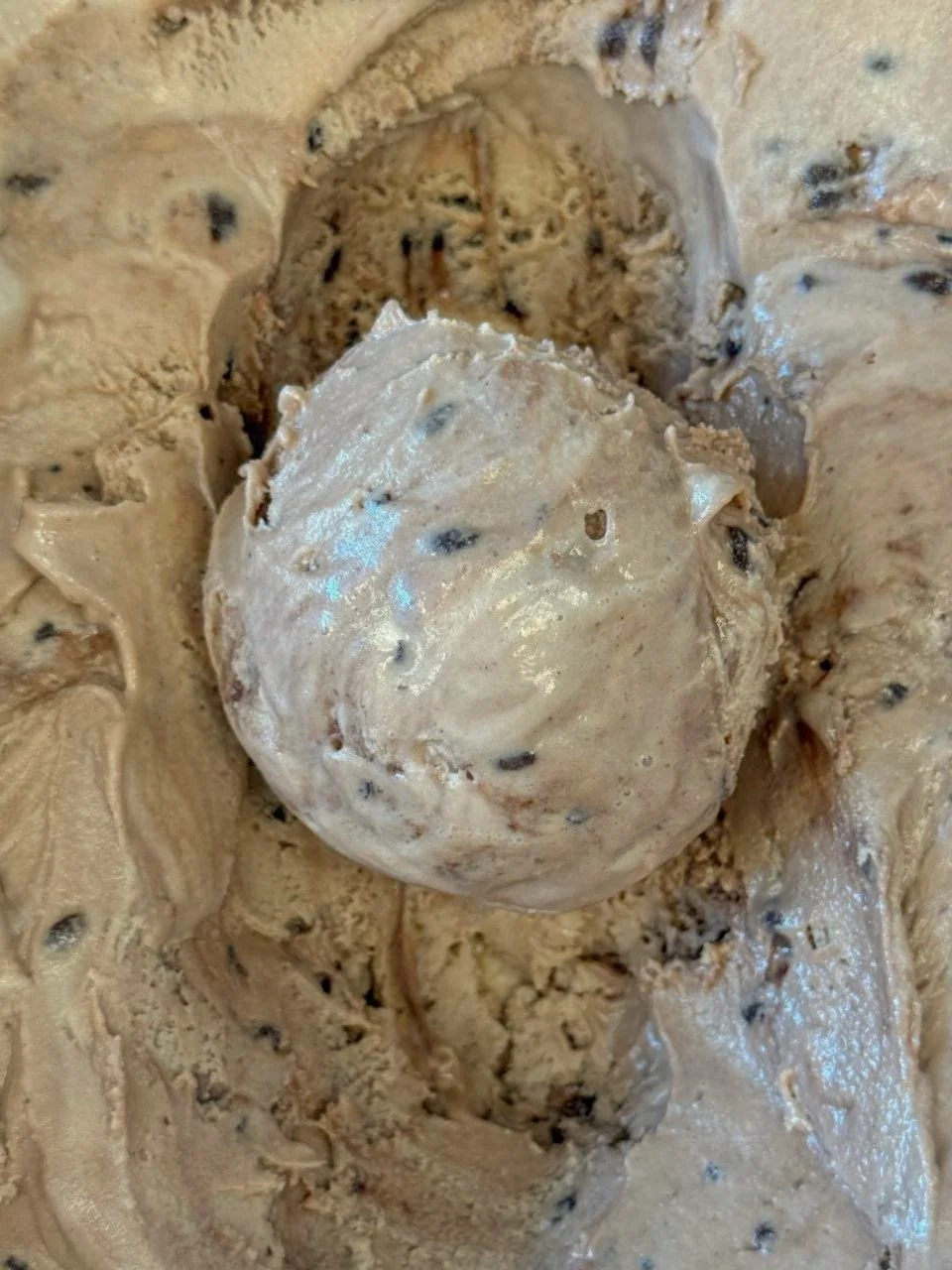Close up of a light brown scoop of Hazelnut Crunch ice cream