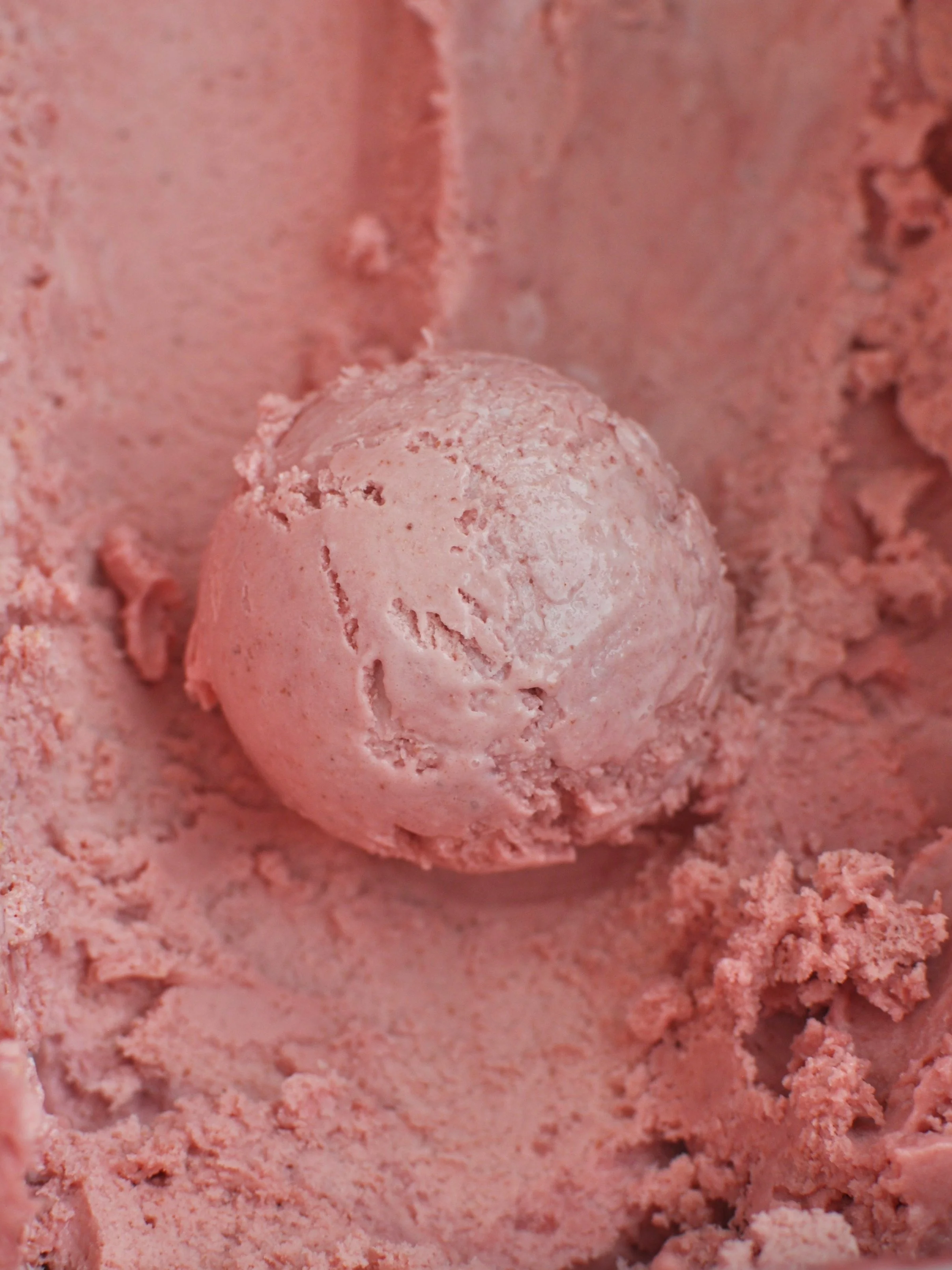 Close up of a pink scoop of Strawberry ice cream. 