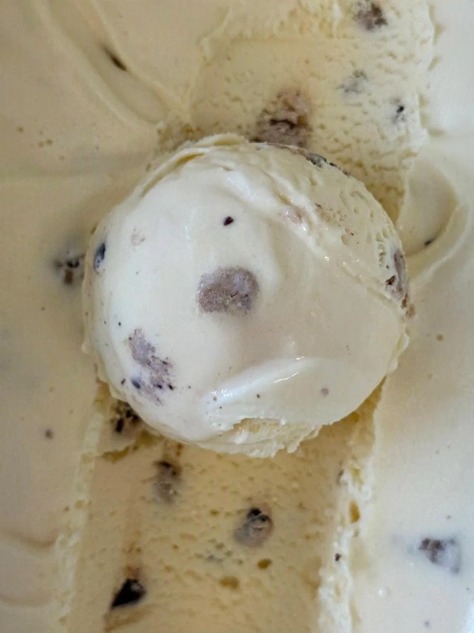 Close up of a white scoop of Cookie Dough ice cream with pieces of Cookie Dough
