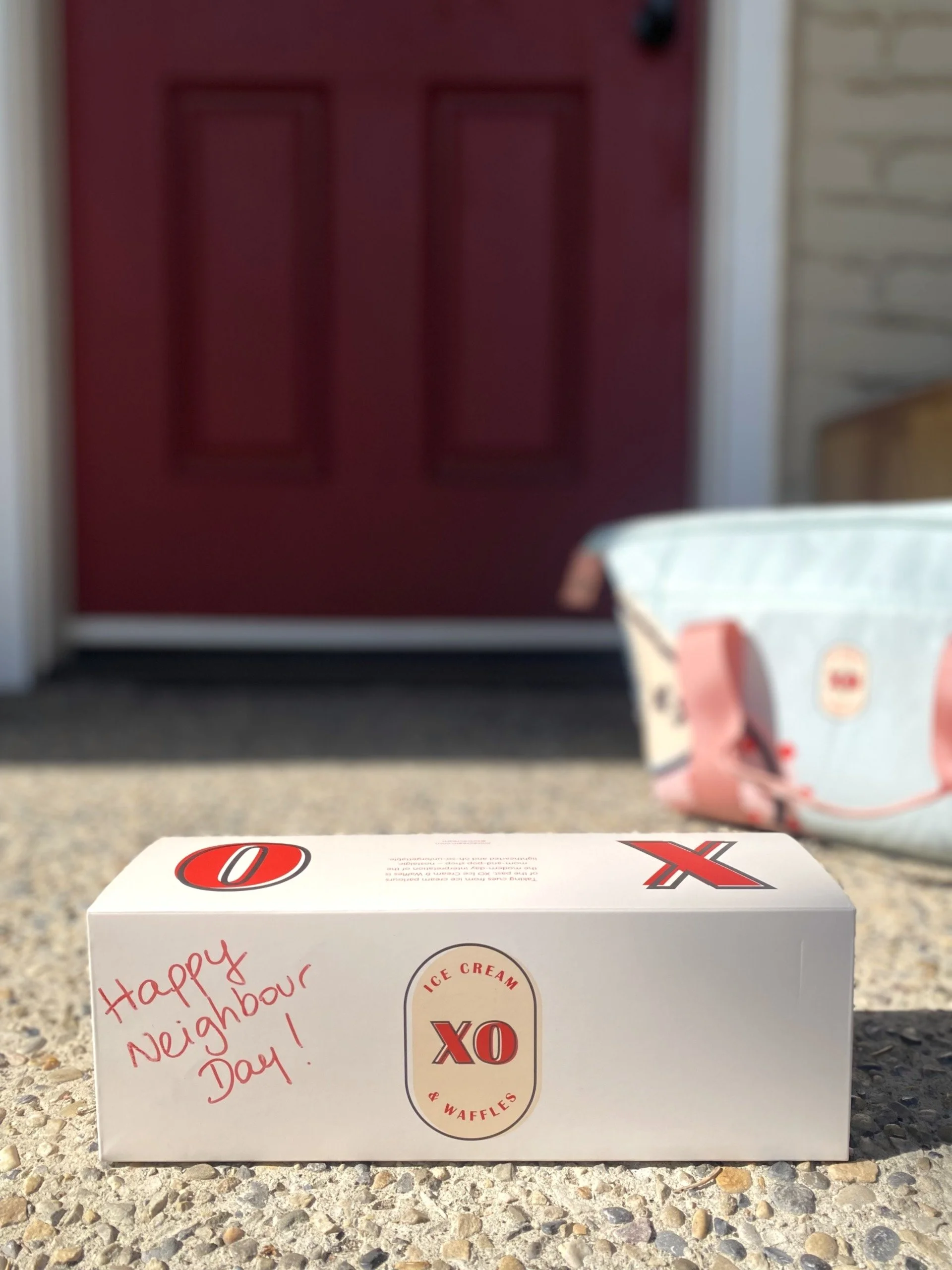 XO gift box containing 3 cube pints of ice cream on a front porch.