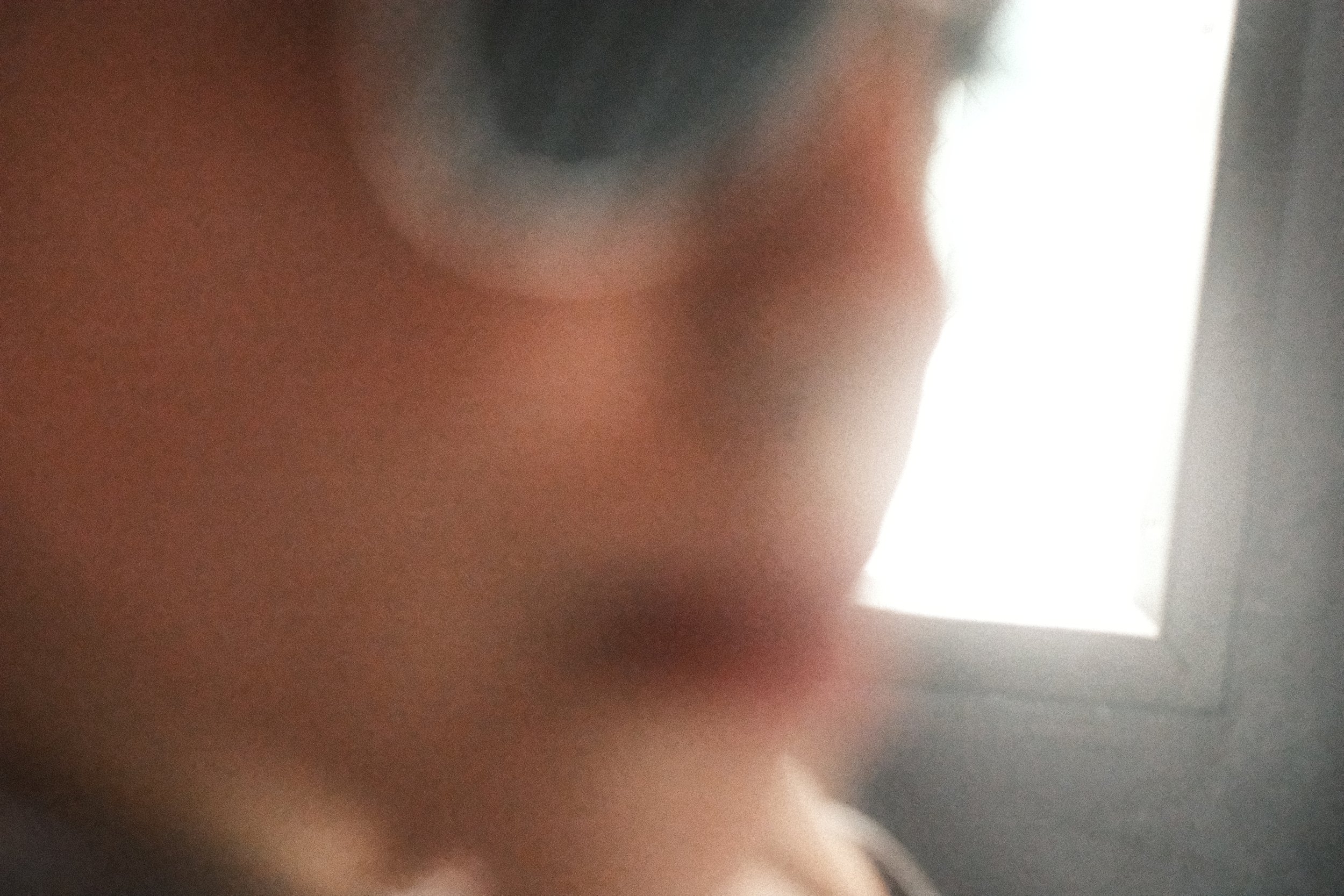 A close-up shot of a person's face, focusing on their nose and part of their lips, with blurred background.