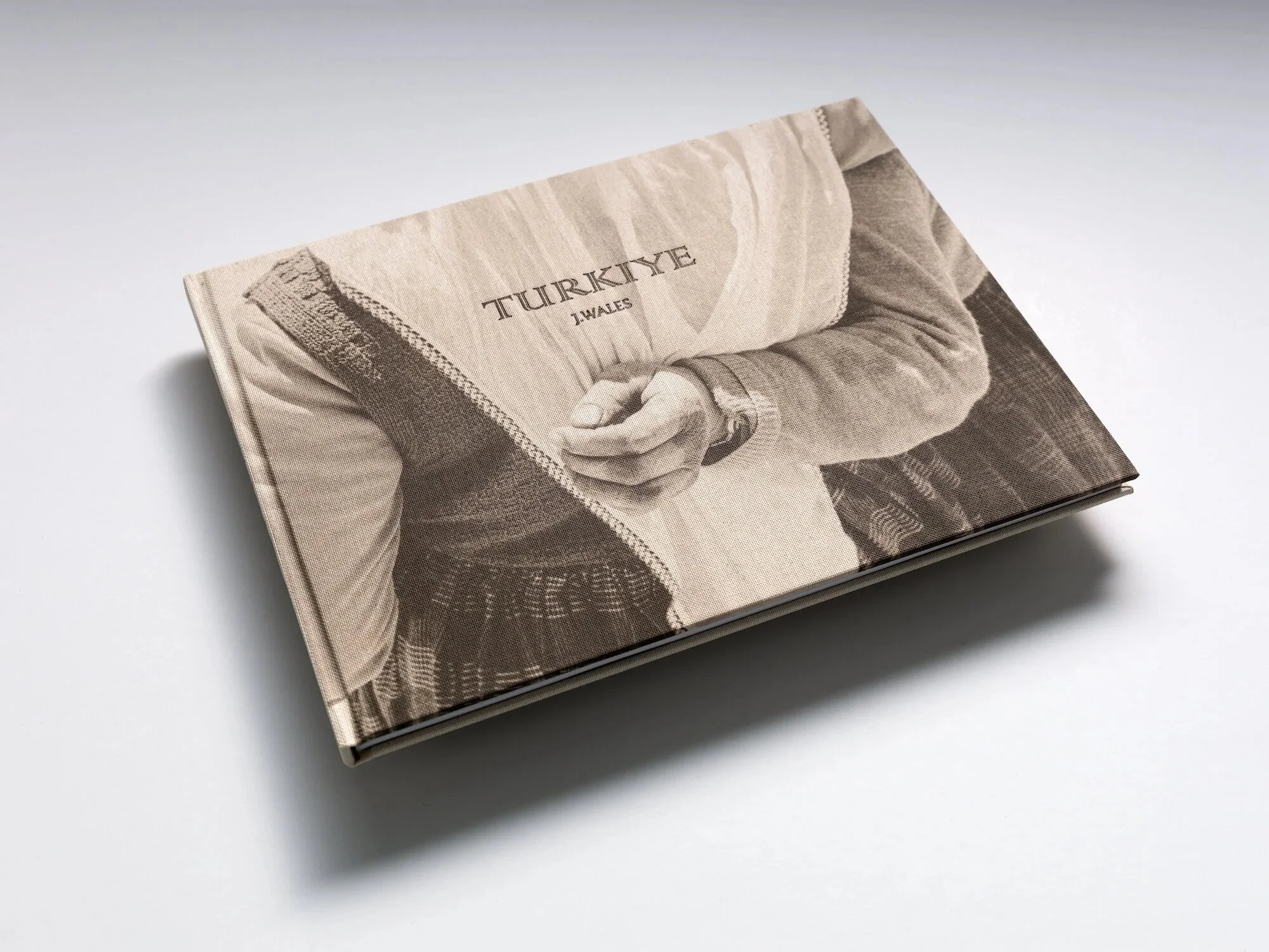 Book with a sepia cover featuring a person in an embrace and the title 'TURKIYE' and photographer 'J. Wales'
