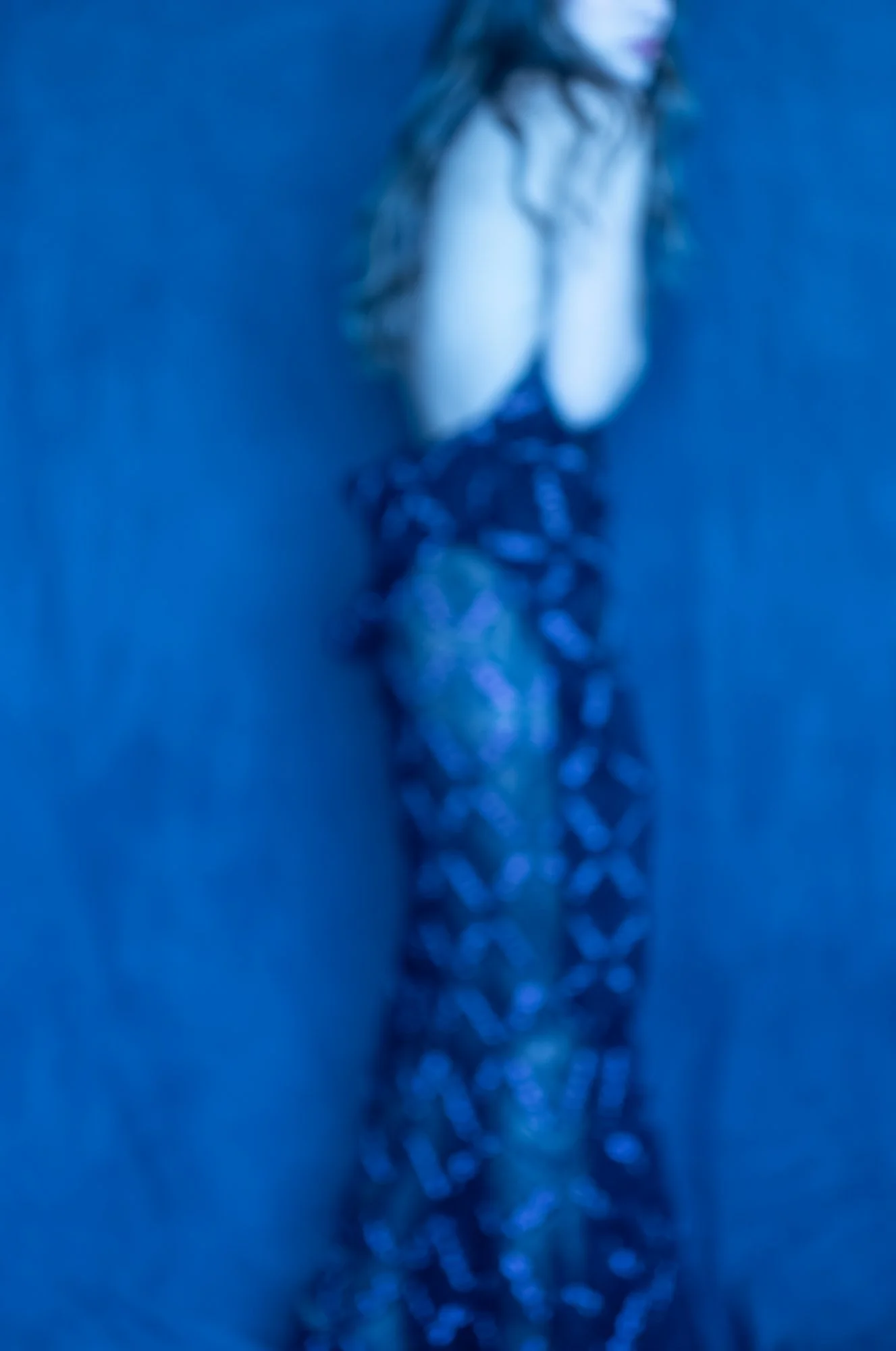 Close-up of a necklace with a star-shaped pendant and white stones on a blue background.