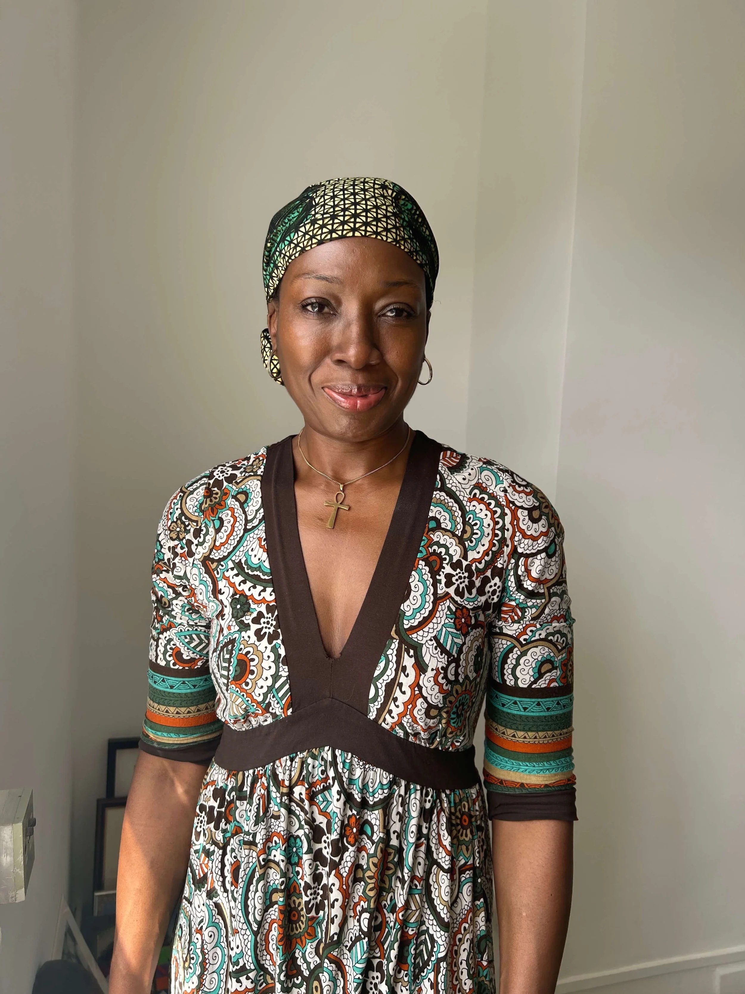 Floerence Okwan profile wearing a patterned dress and earings