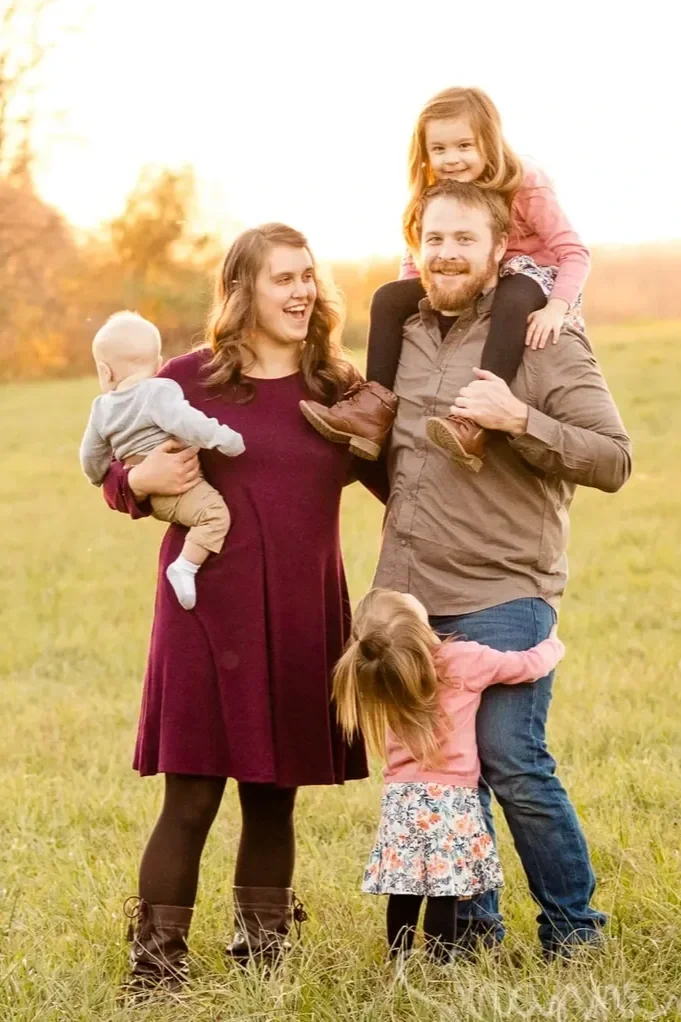 Family of five outdoors during sunset.