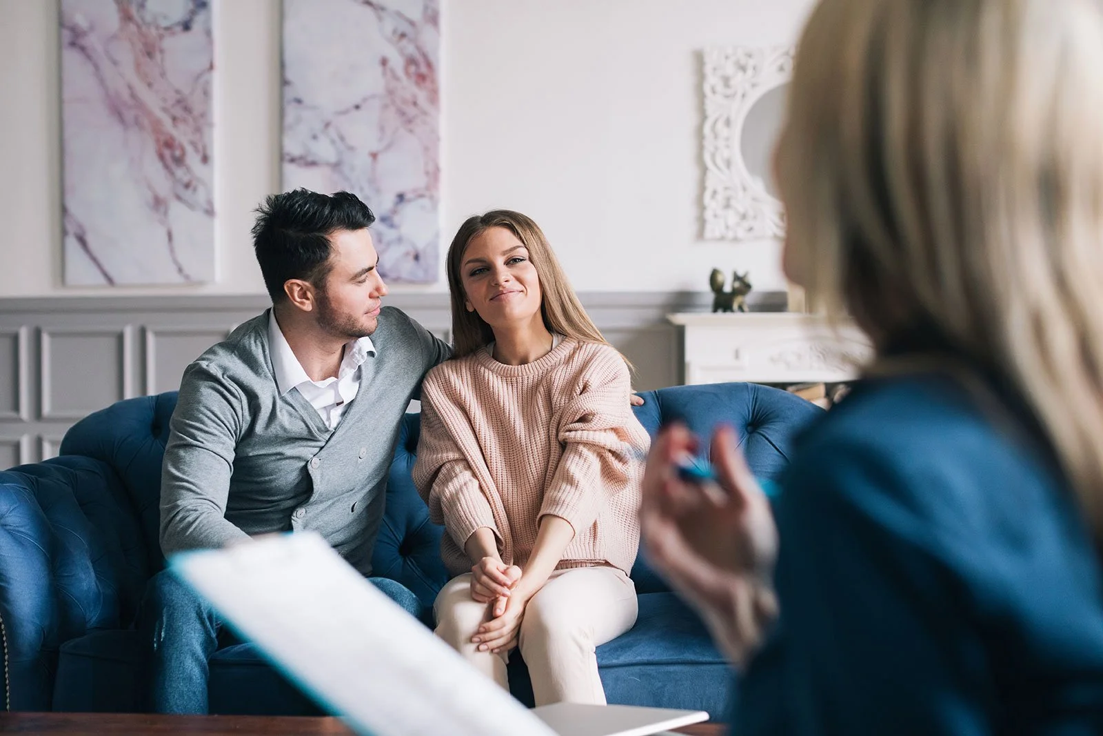 Young couple talking with a therapist or counselor in a comforting setting.