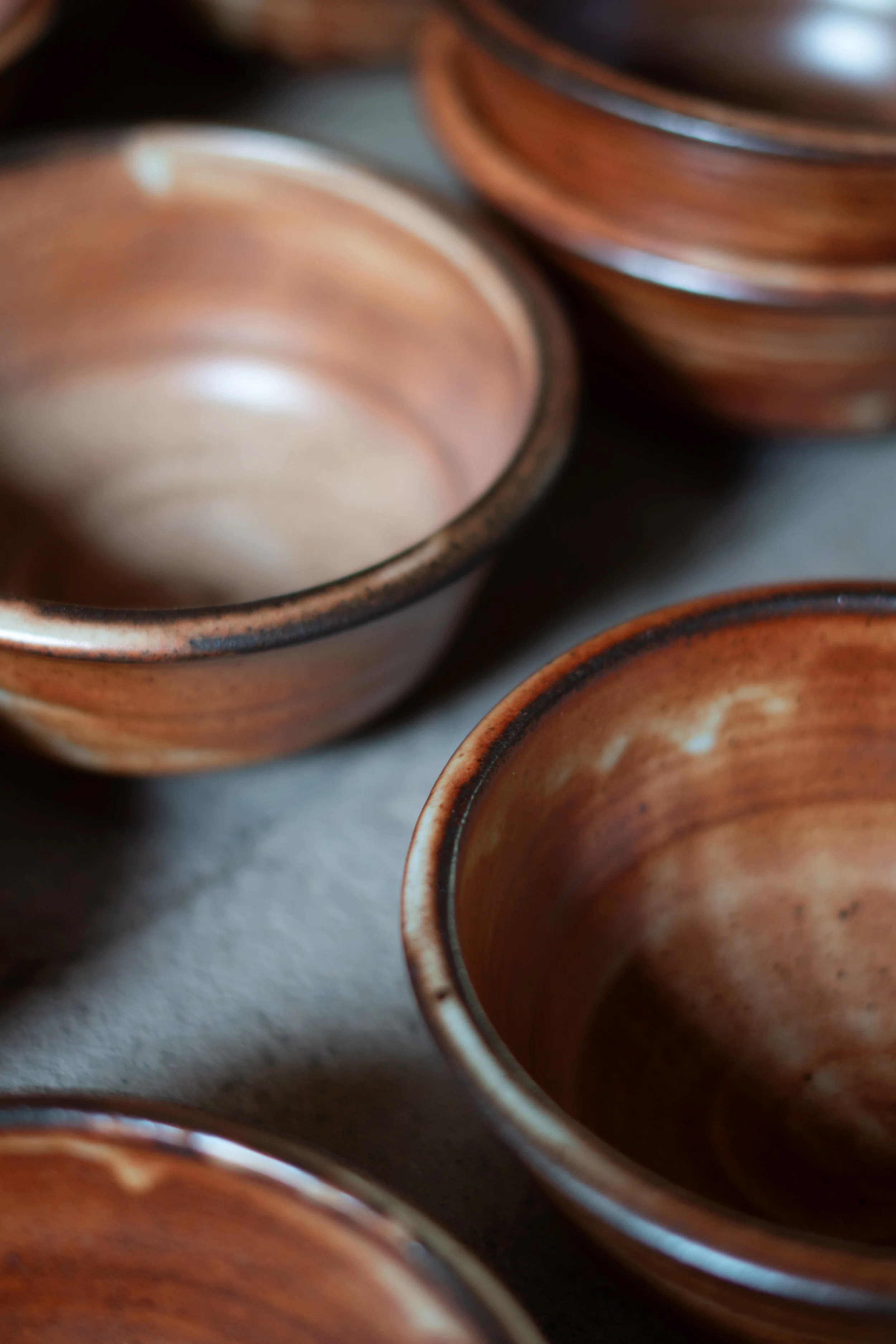 Close-up of stacked clay pots with a reddish-brown glaze.