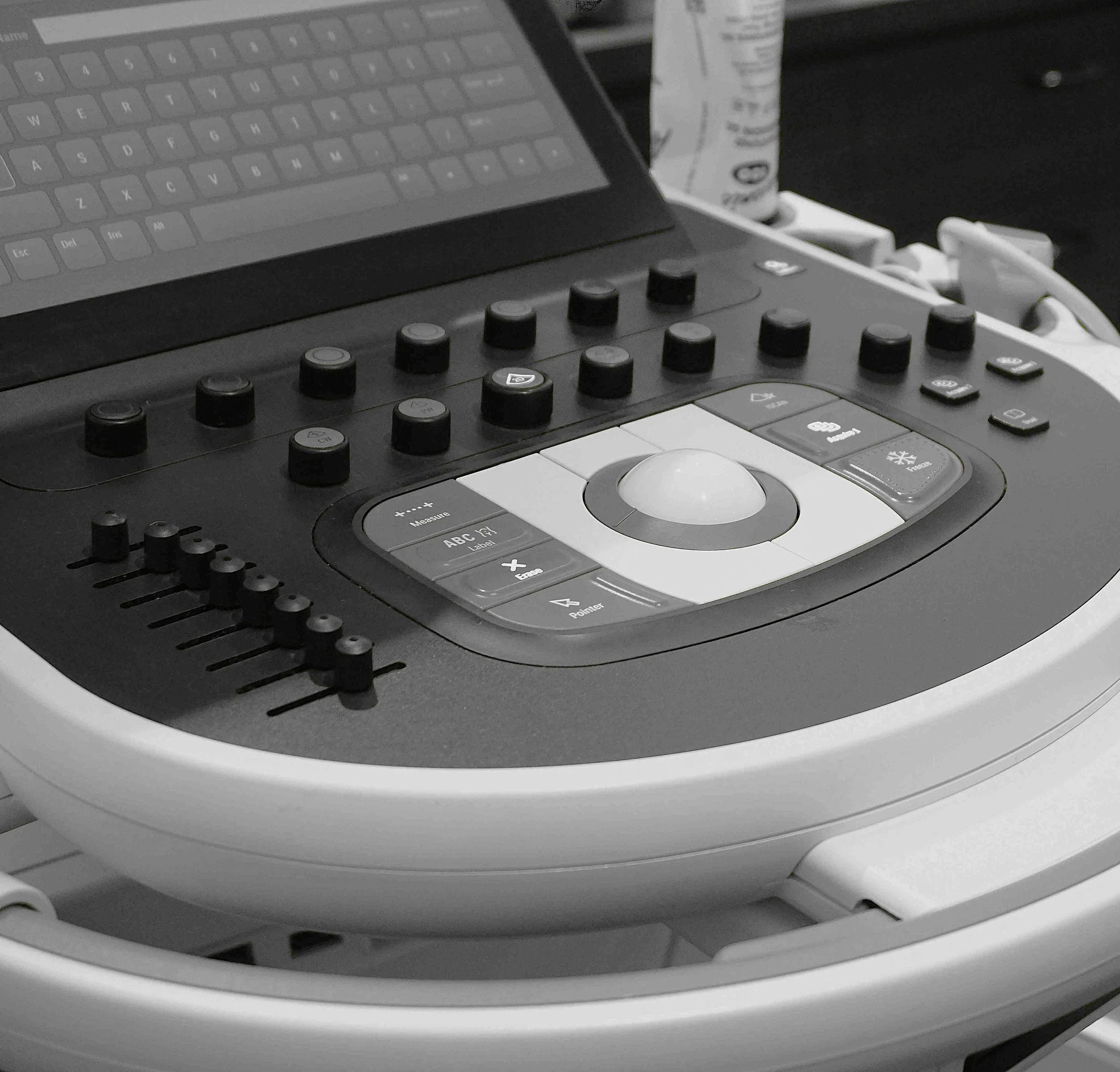 Close-up of a professional audio mixing console with various knobs, buttons, and a touchscreen display.