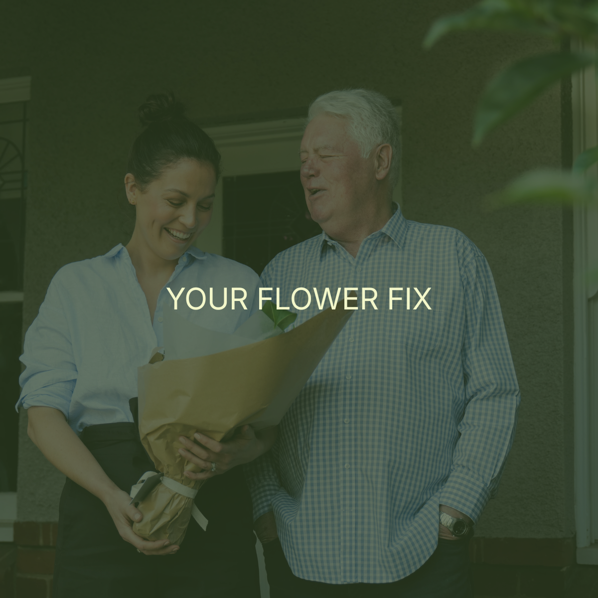 A woman receives a flower bouquet from a man outside a house. Both are smiling and appear happy.
