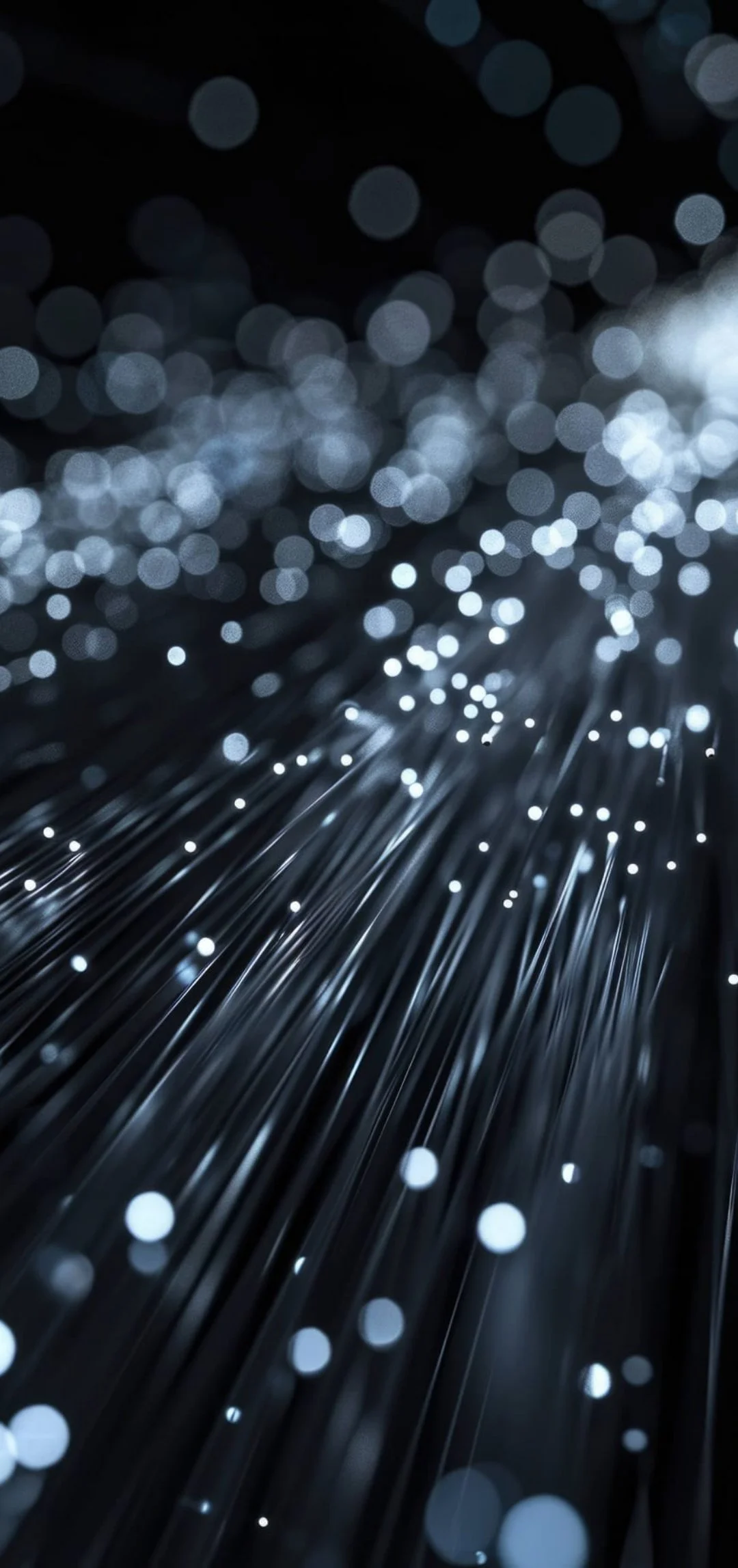 Close-up of fiber optic cables with glowing tips, creating a bokeh effect in the background.