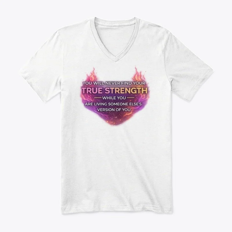 White V-neck T-shirt with a motivational quote and colorful graphic design. The quote reads, 'You will never find your true strength while you are living someone else's version of you,' with emphasis on 'true strength' in bold, pink, and yellow text, surrounded by a fiery, cosmic-themed graphic.