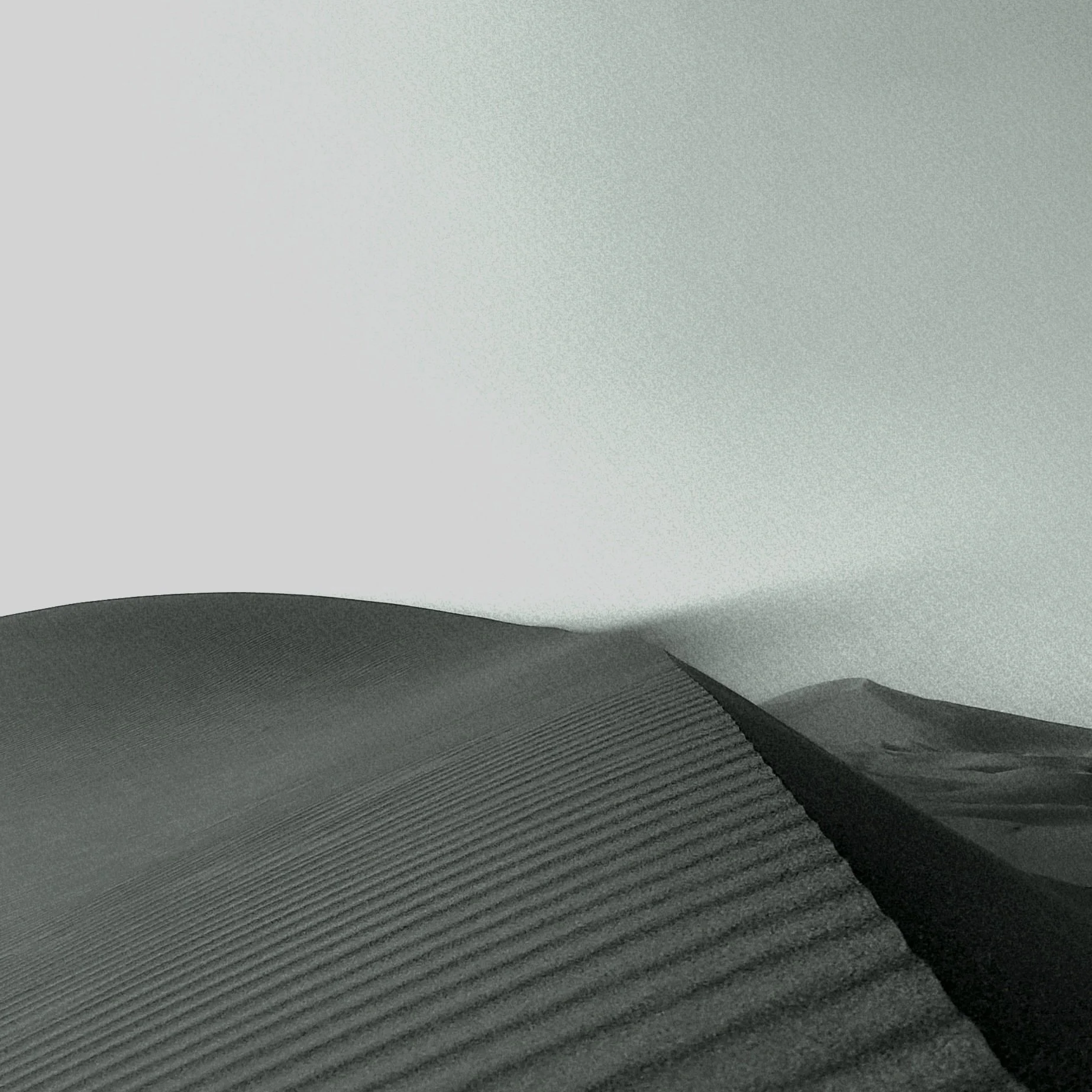 Dune de sable en noir et blanc avec le sable qui s'envole