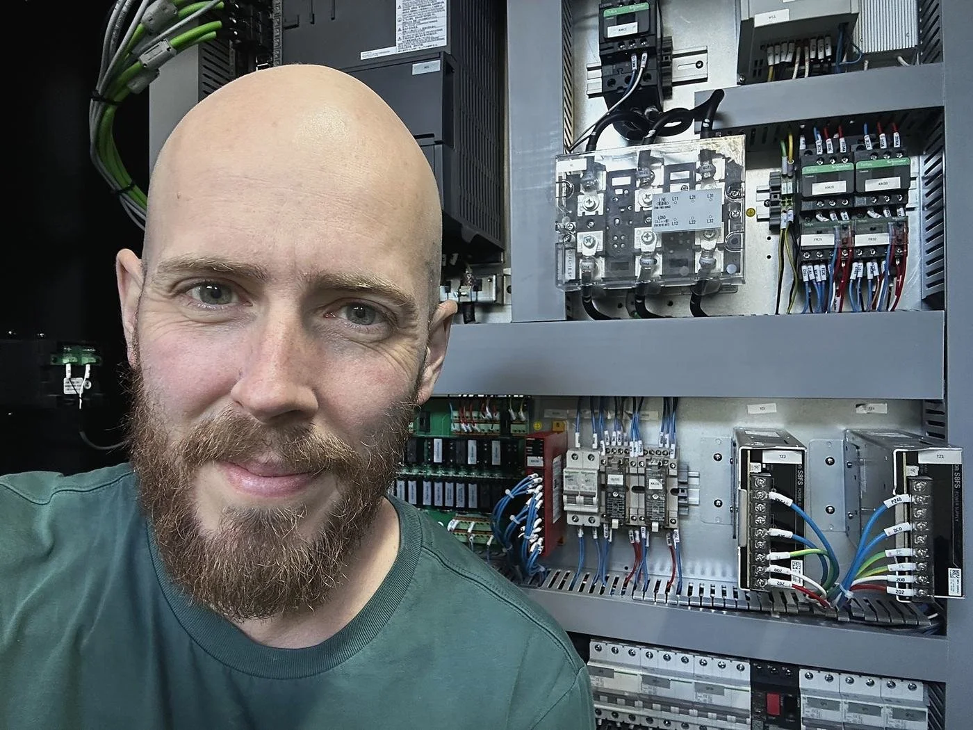 Ben Kitcher in front of the electrical cabinet of a Taikan T-V856S