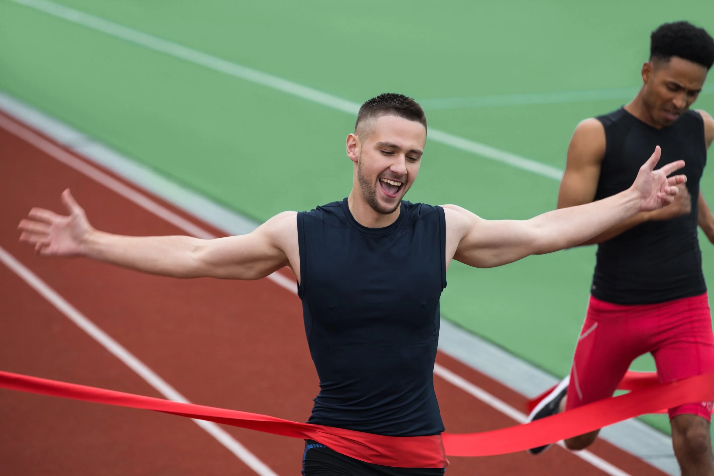 cheerful-young-athlete-man-crossing-finish-line.jpg