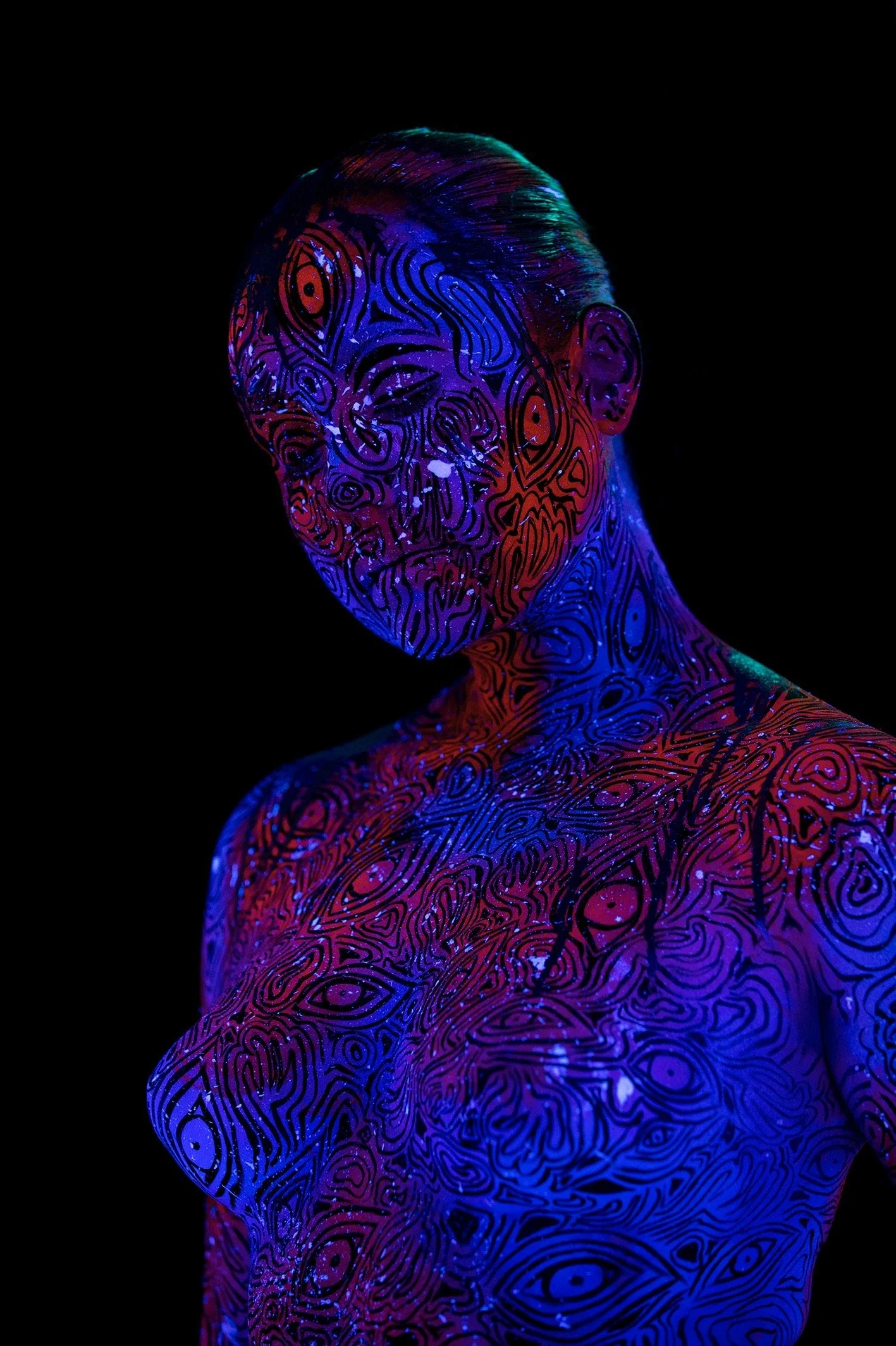 Portrait d'une personne avec un corps et un visage recouverts de motifs colorés fluorescents, rendu artistique et futuriste. Fond noir.